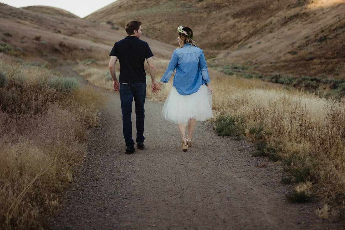 Husband and wife running up a hill at Keystone Canyon in Reno, NV 