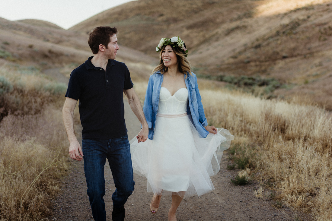 Husband and wife running down a hill for their anniversary pictures