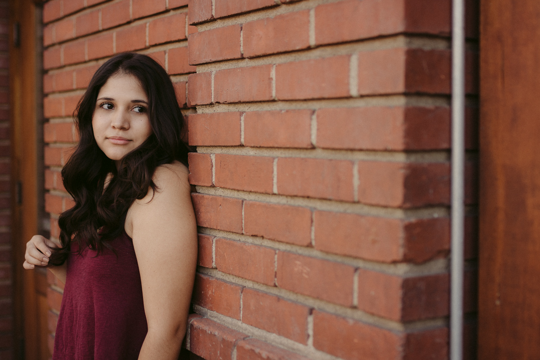 Lake Tahoe senior pictures of a girl leaning on a brick wall 