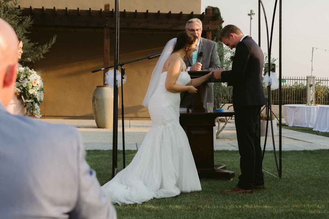 California Wedding private venue bride sliding ring on grooms finger 