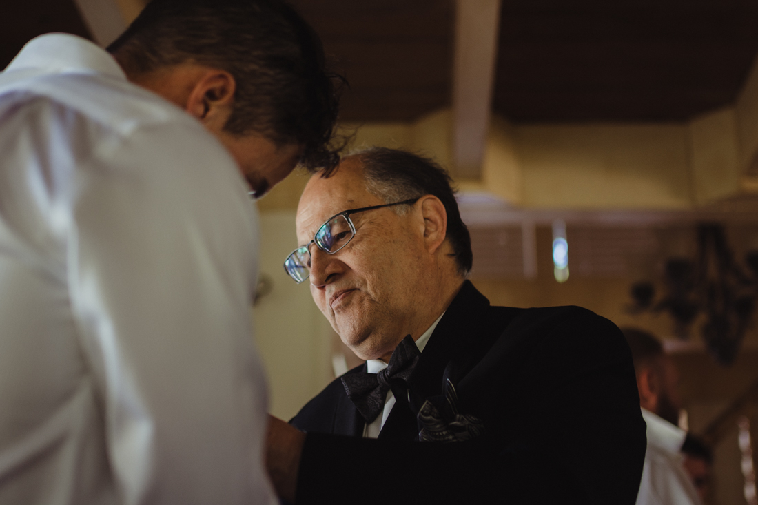 Incline Village wedding dad helping groom put on his bowtie photo