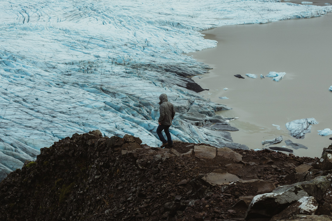 Guy walking by a glacier in Iceland
