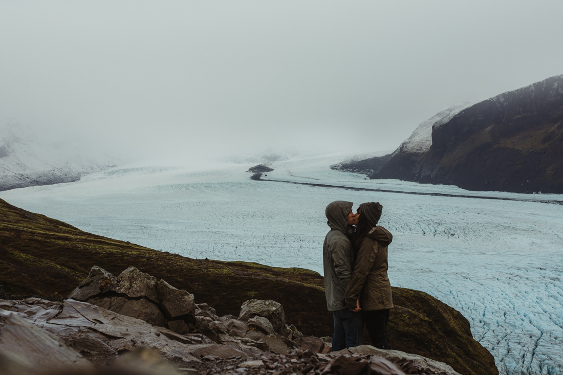 couple kissing next to a glacier in Iceland
