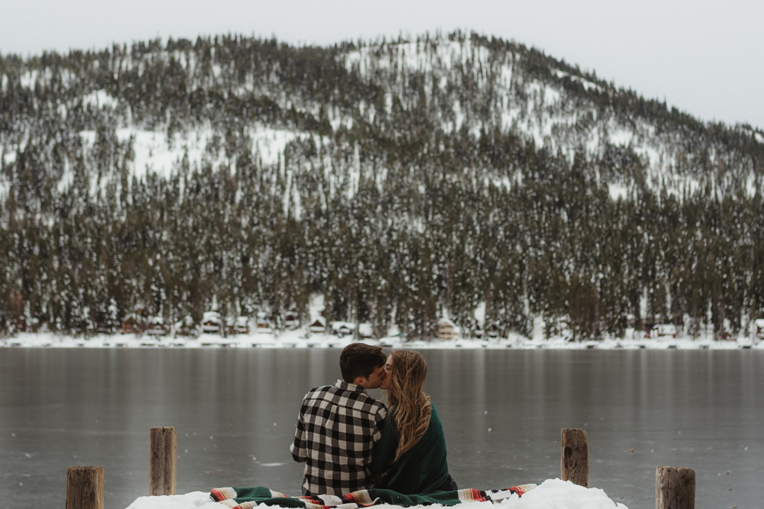 Couple sitting at the edge of a dock in Donner CA photo