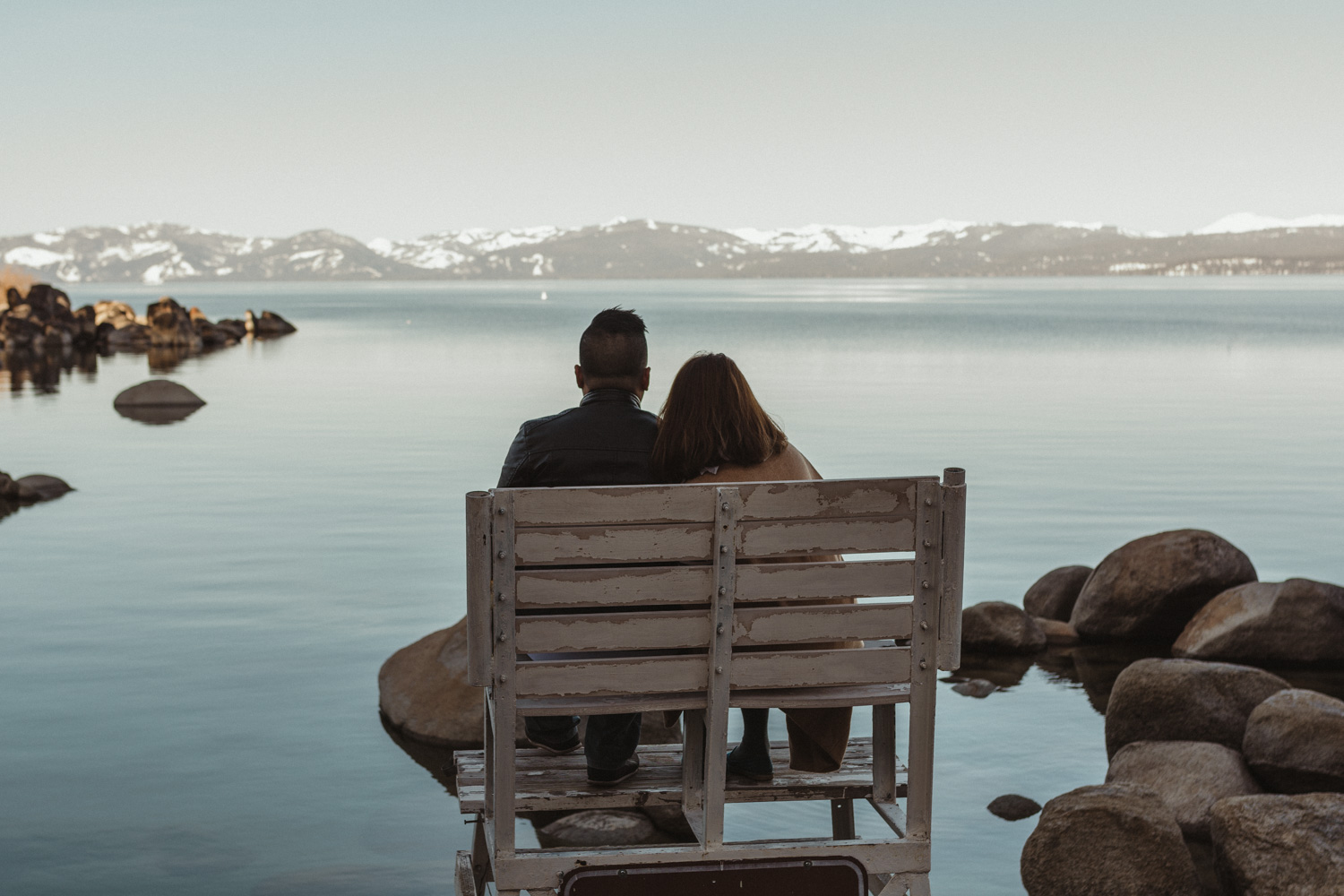 Lake Tahoe engagement session couple sitting down looking at the lake photo