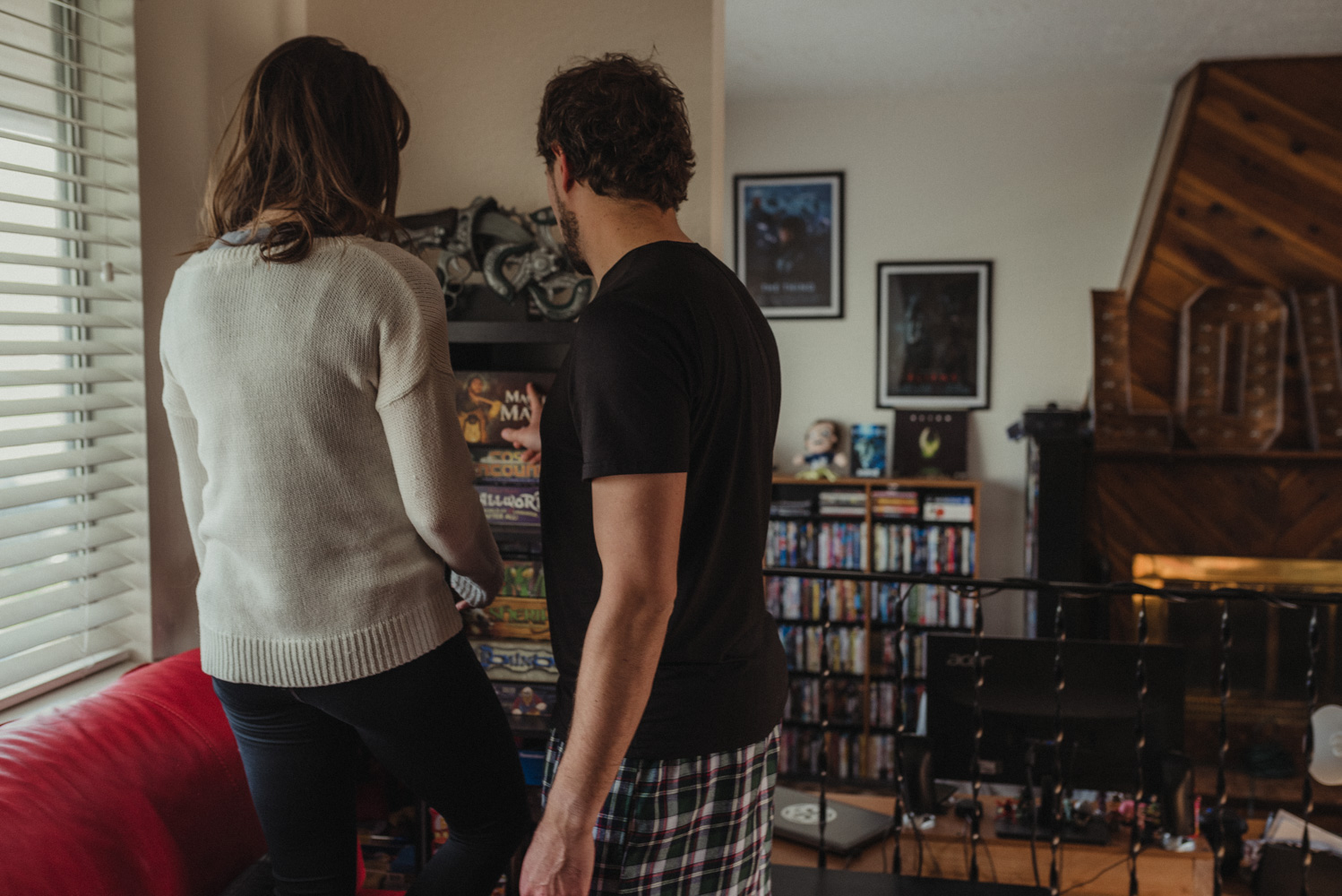 Home session- couple choosing a board game for their engagement photos.  