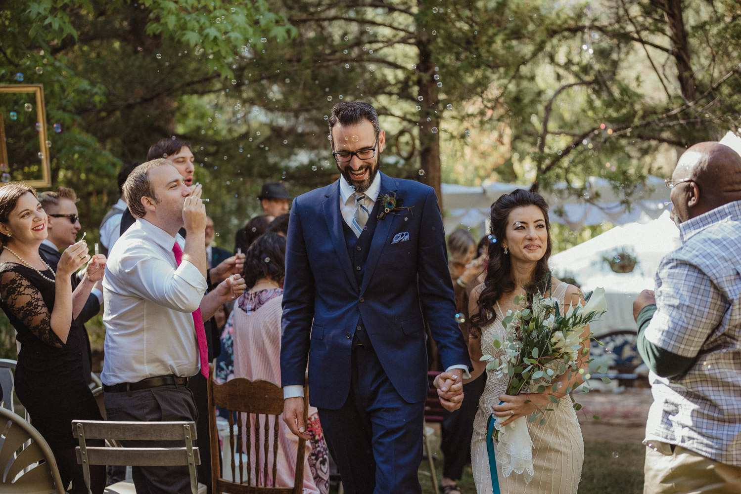 Nevada City wedding bride and groom walking down the aisle as guests blow bubbles photo
