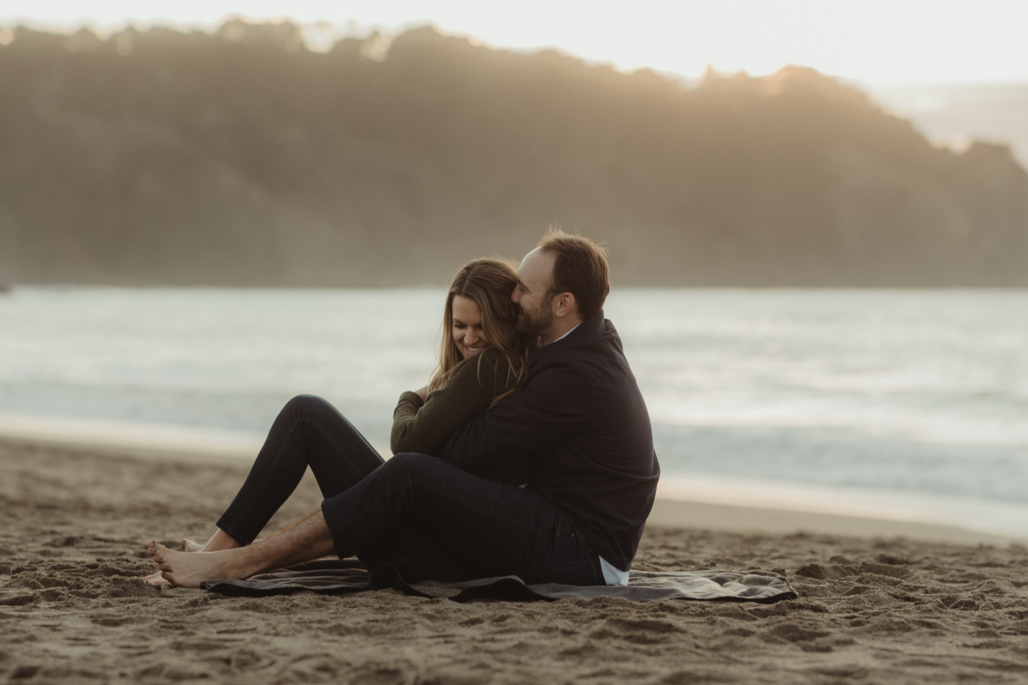 San Francisco engagement couple cuddling at Baker Beach photo