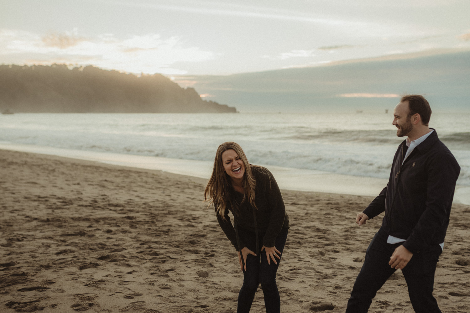 San Francisco engagement couple laughing at Baker Beach photo