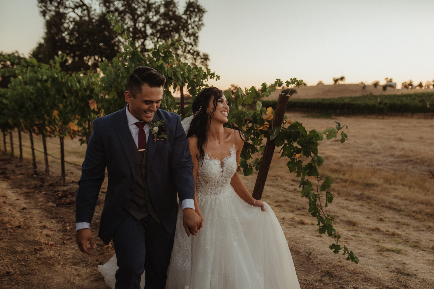 Rancho Victoria Vineyards wedding couple walking through the vineyard photo