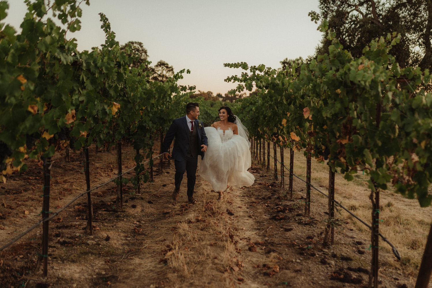 Ranch Victoria vineyard wedding couple running in the vineyard photo