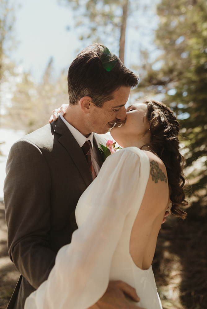 Emerald Bay Elopement in April, couple kissing in the tahoe forest photo