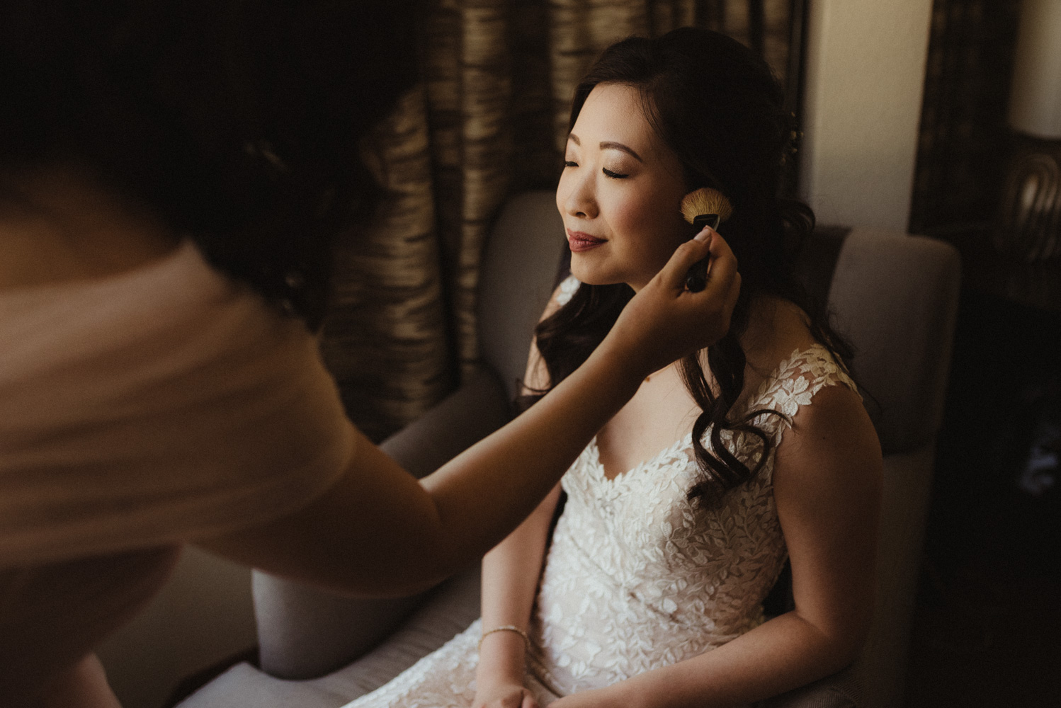 Hellman-Erman Mansion Wedding, photo of bride getting her makeup done by her sister