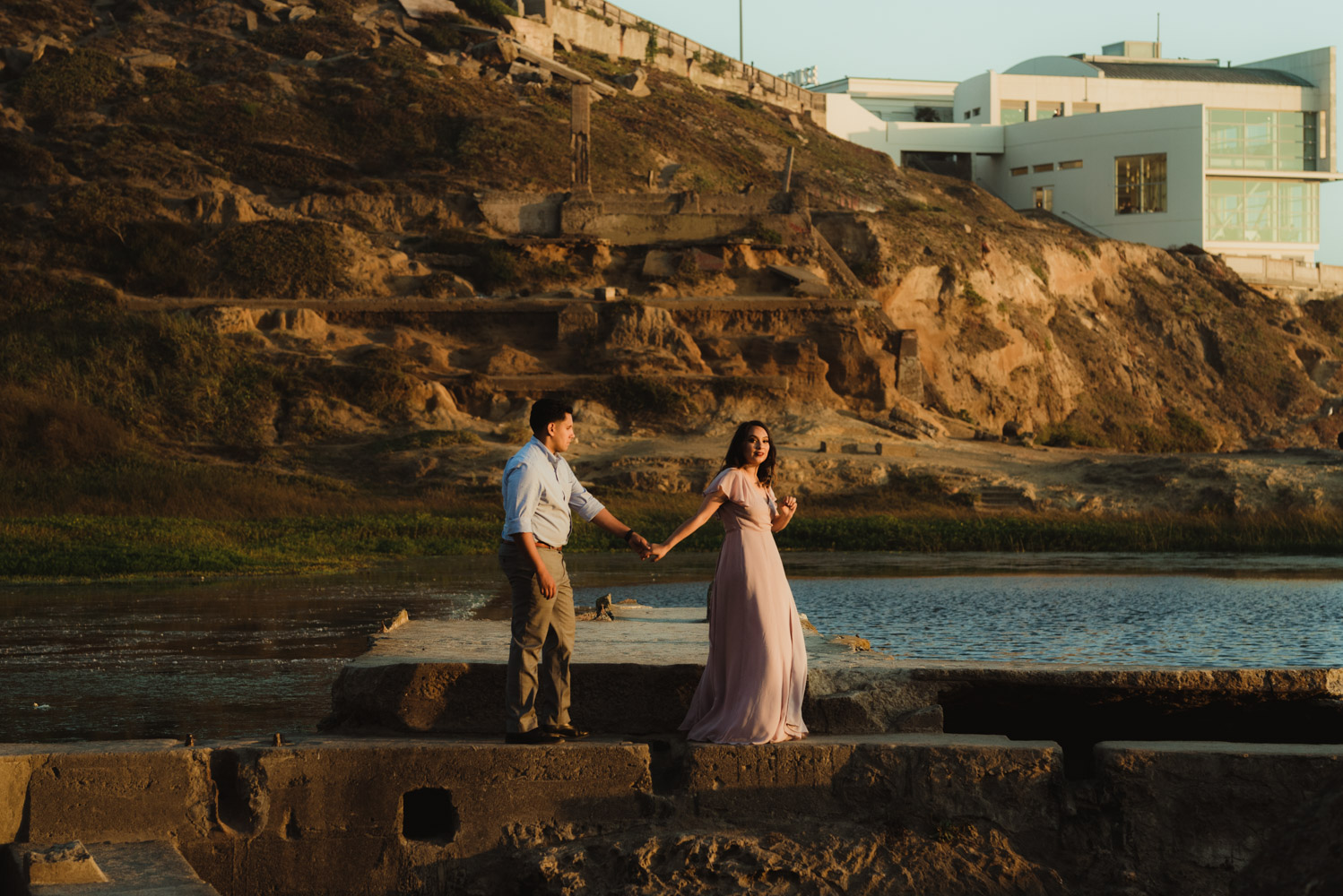 Sutro Baths Engagement Session, photo of couple holding hands with the ocean in the background