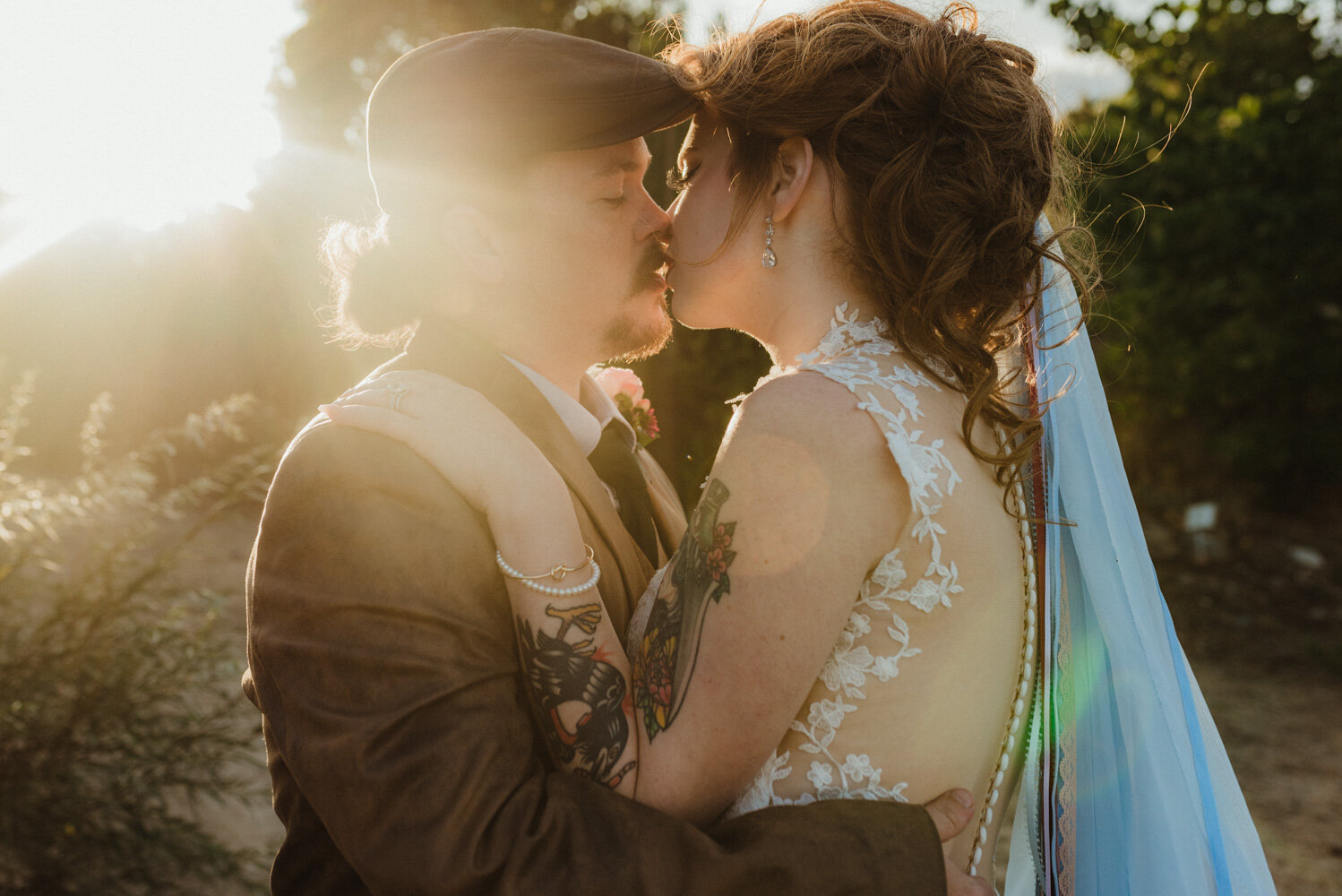 River School Farm Wedding, photo of couple kissing with the sun peaking behind them