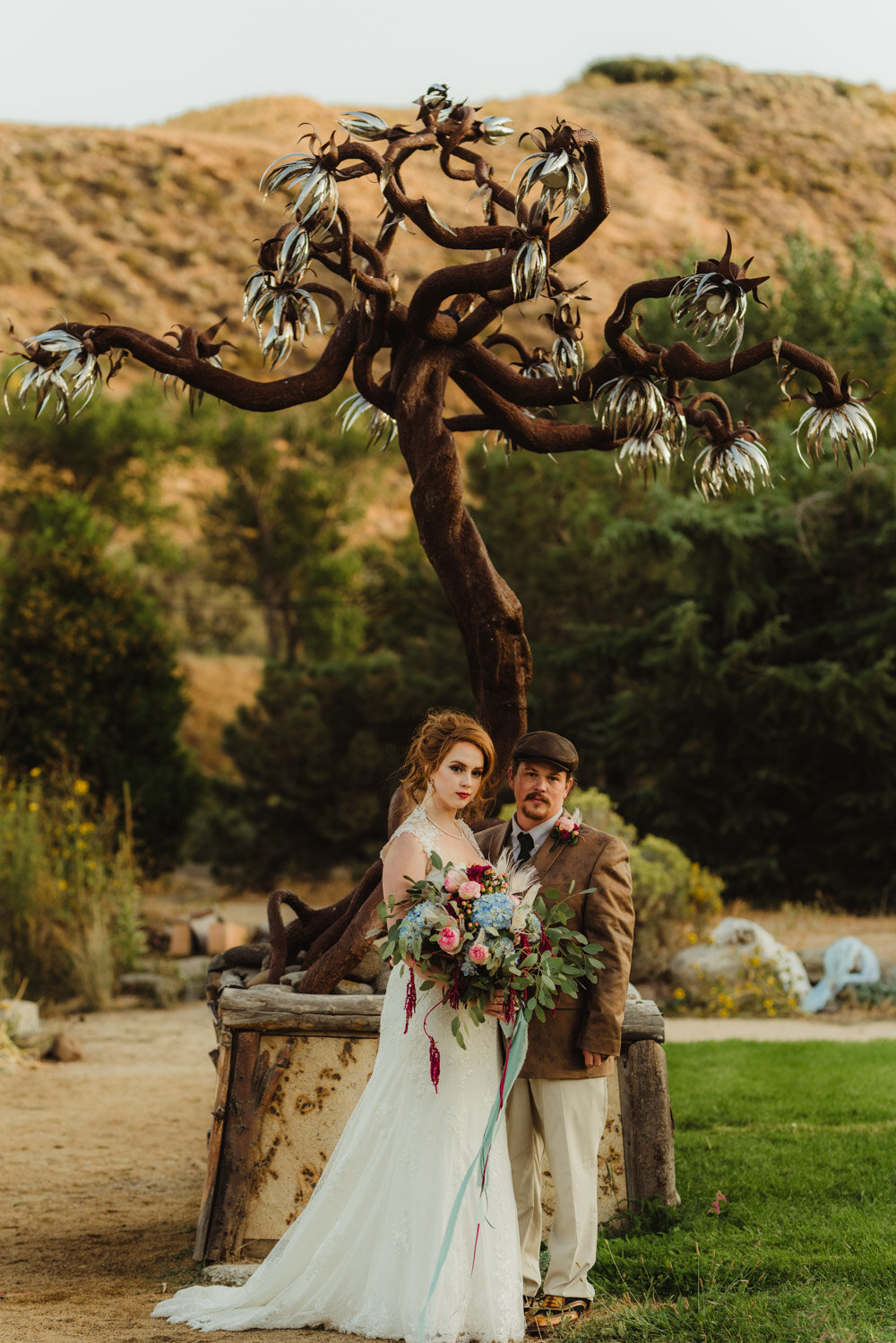 River School Farm Wedding, photo of couple in front of a burning man like sculpture 