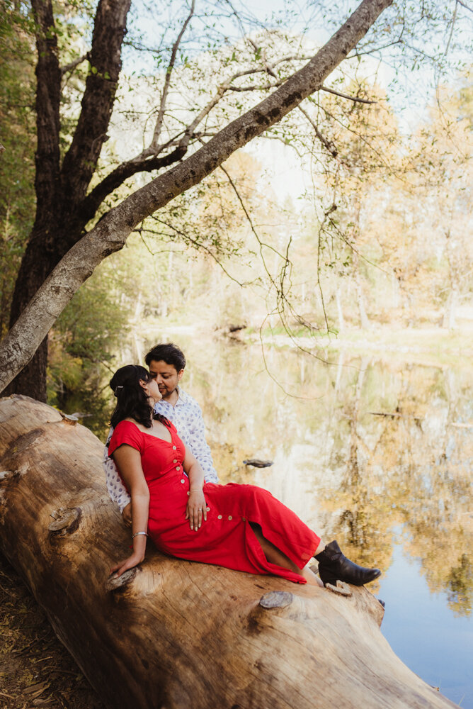 Yosemite Engagement Session, couple sitting on a log overlooking yosemite photo