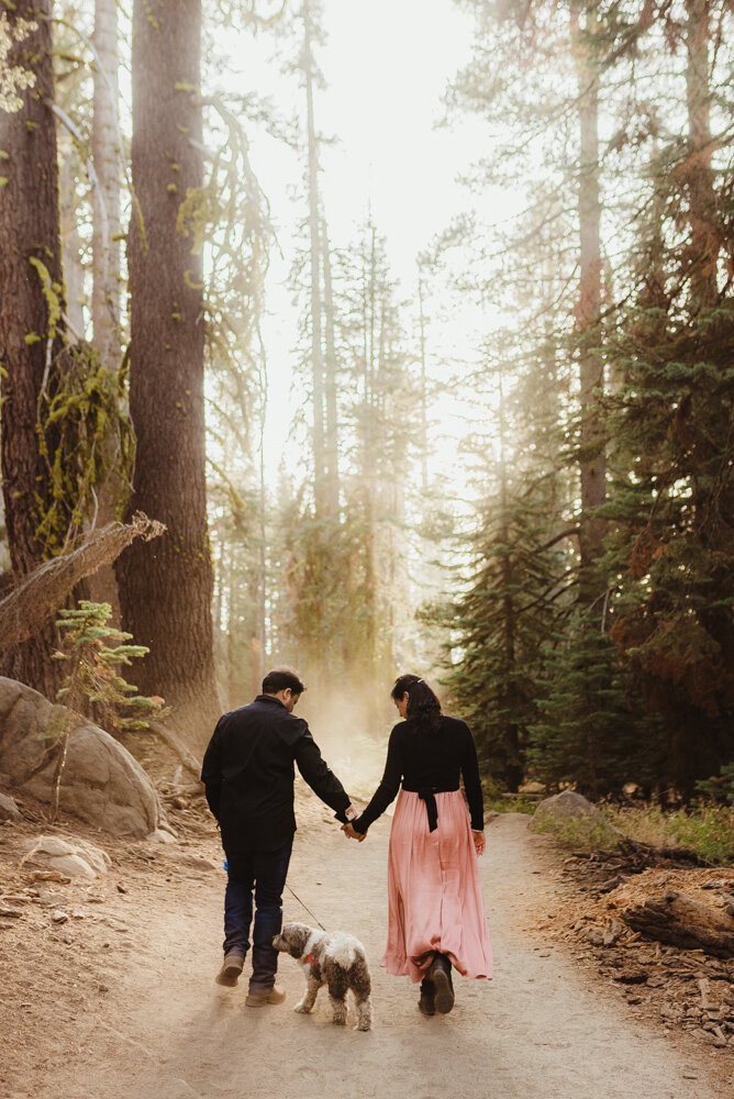 Yosemite Engagement Session, couple walking on taft point trail with dust and sun in the background