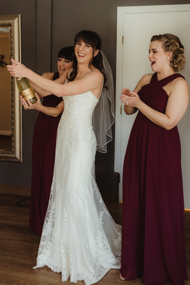 Tannenbaum Wedding Venue, photo of bride popping champagne 