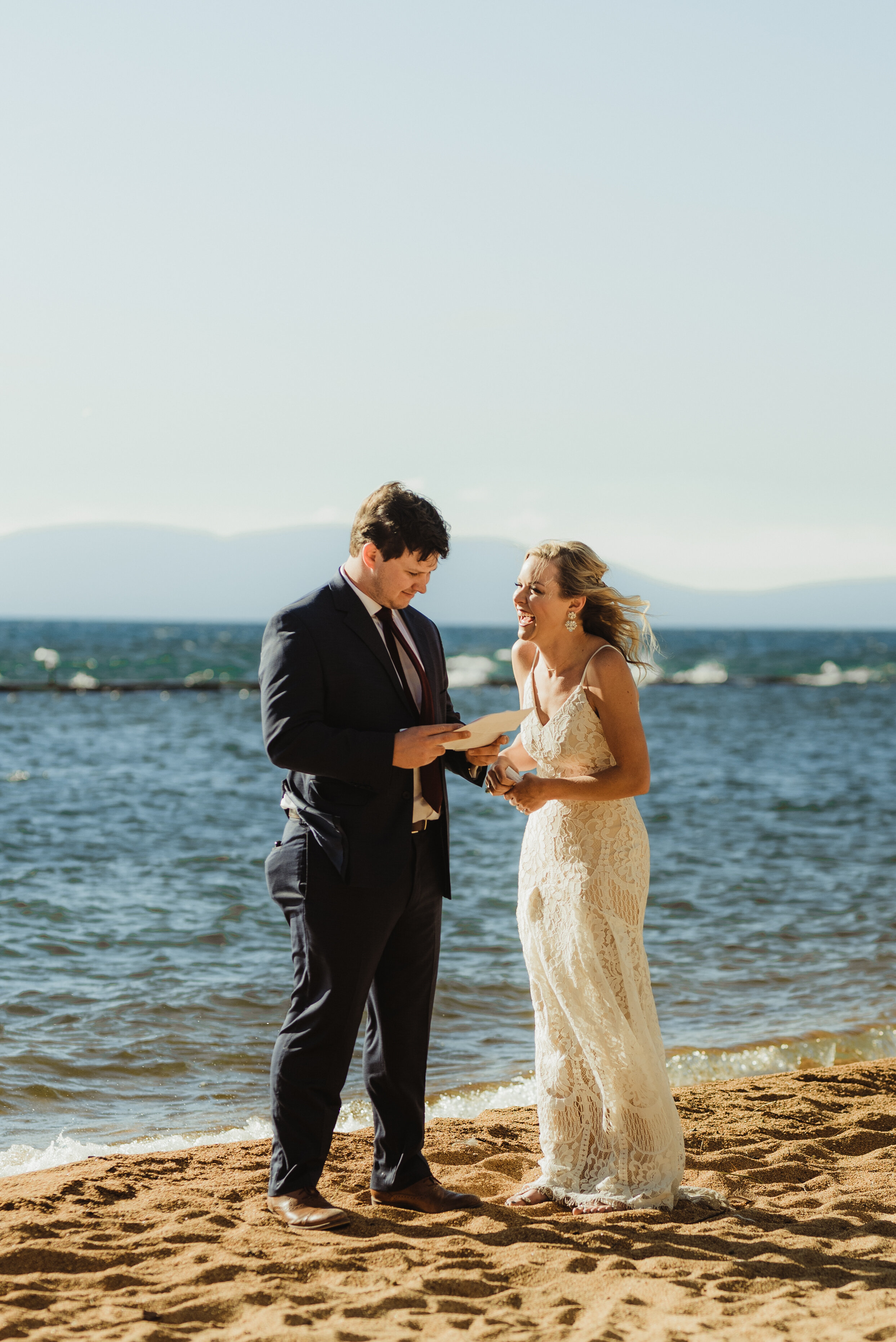 lake tahoe elopement, couple reading wedding letters by the lake photo