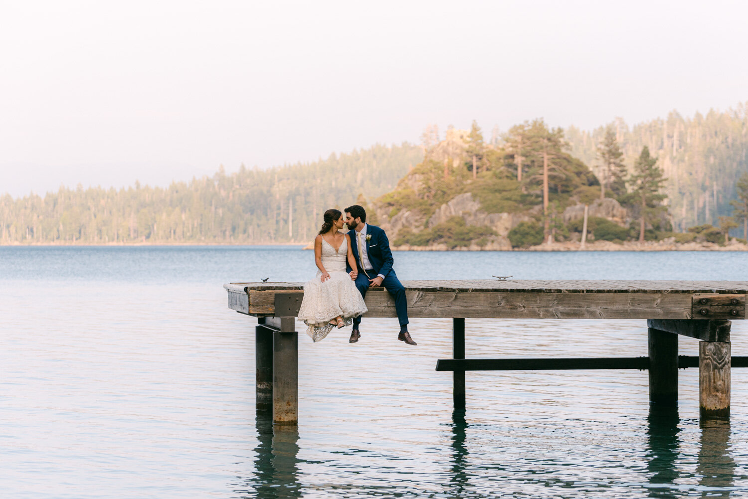 COVID Wedding in Lake Tahoe, couple sitting on a dock with emerald bay in the background