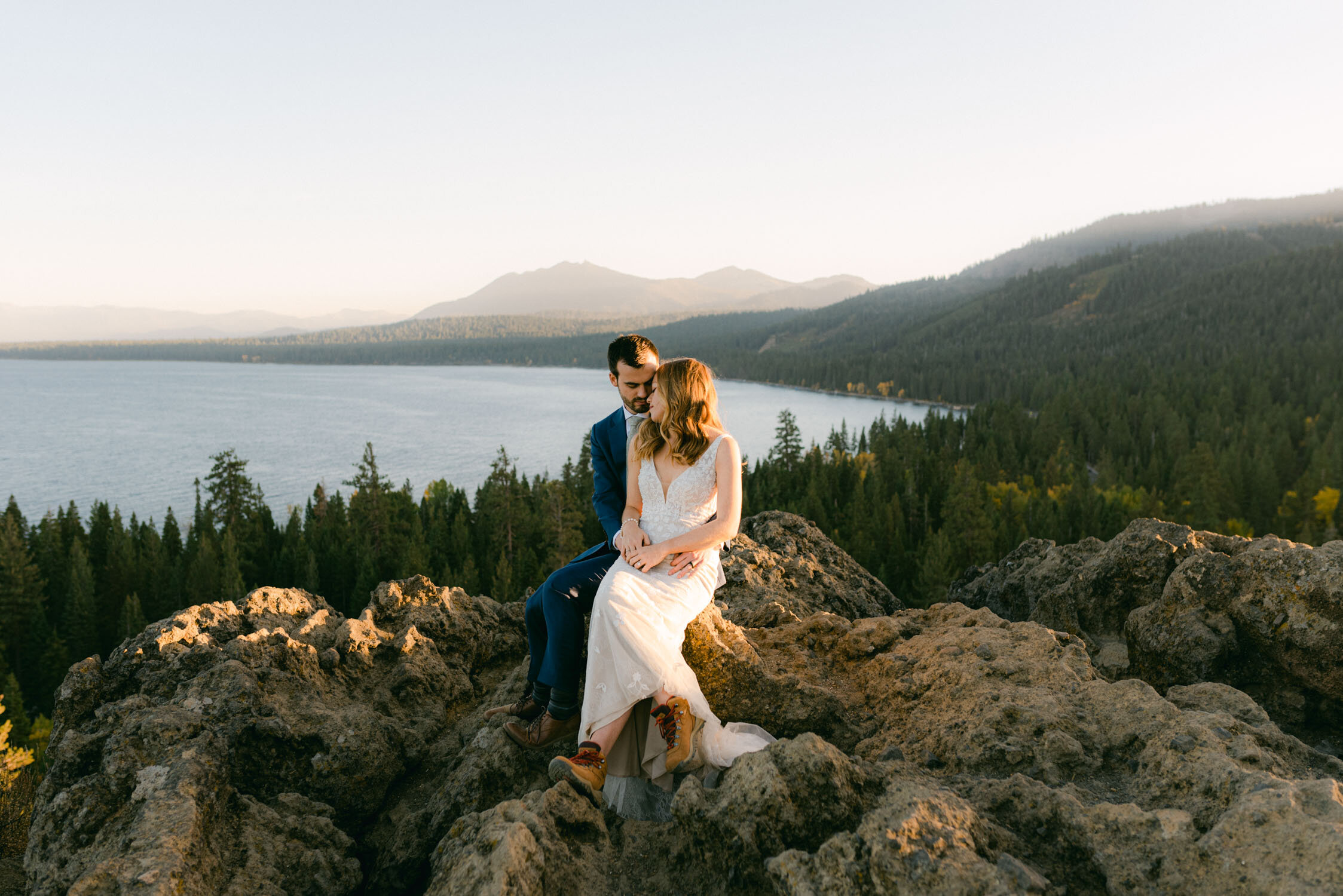 Fall elopement in Lake Tahoe, photo of couple sitting on a cliff overlooking tahoe