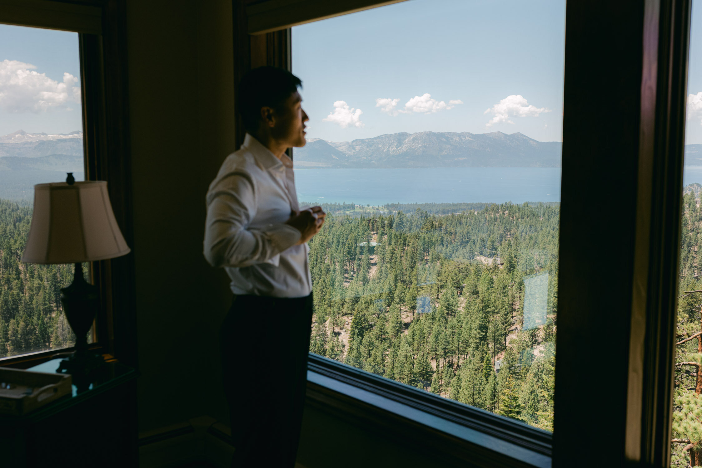 Tahoe Blue Estate Wedding photo of groom looking out the window, that overlooks Lake Tahoe
