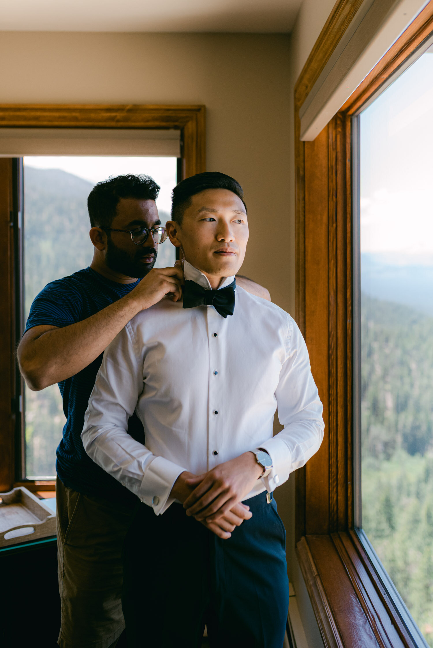 Tahoe Blue Estate Wedding photo of groomsmen helping the groom put on the bowtie 