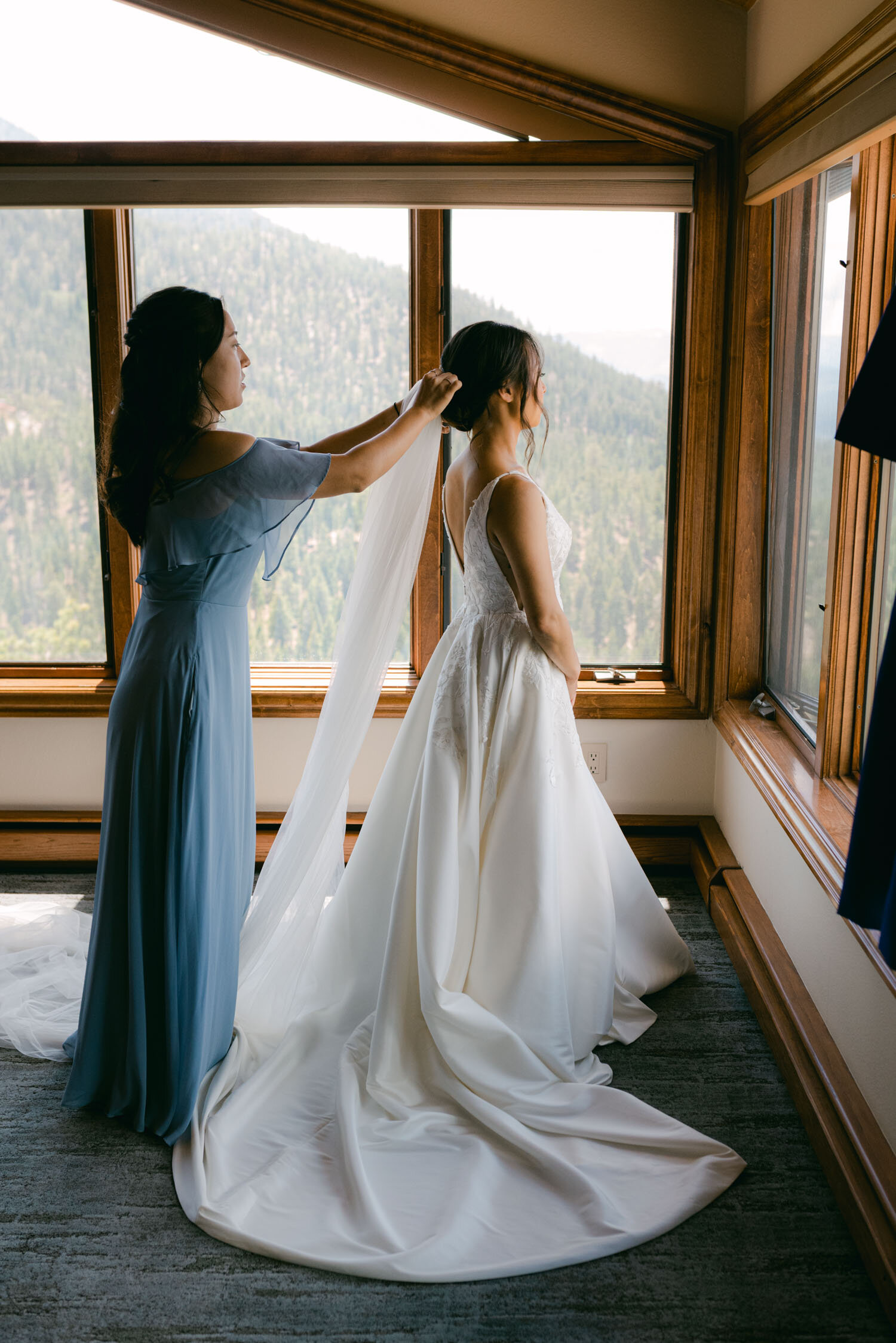 Tahoe Blue Estate Wedding photo of bride's sister helping with the veil