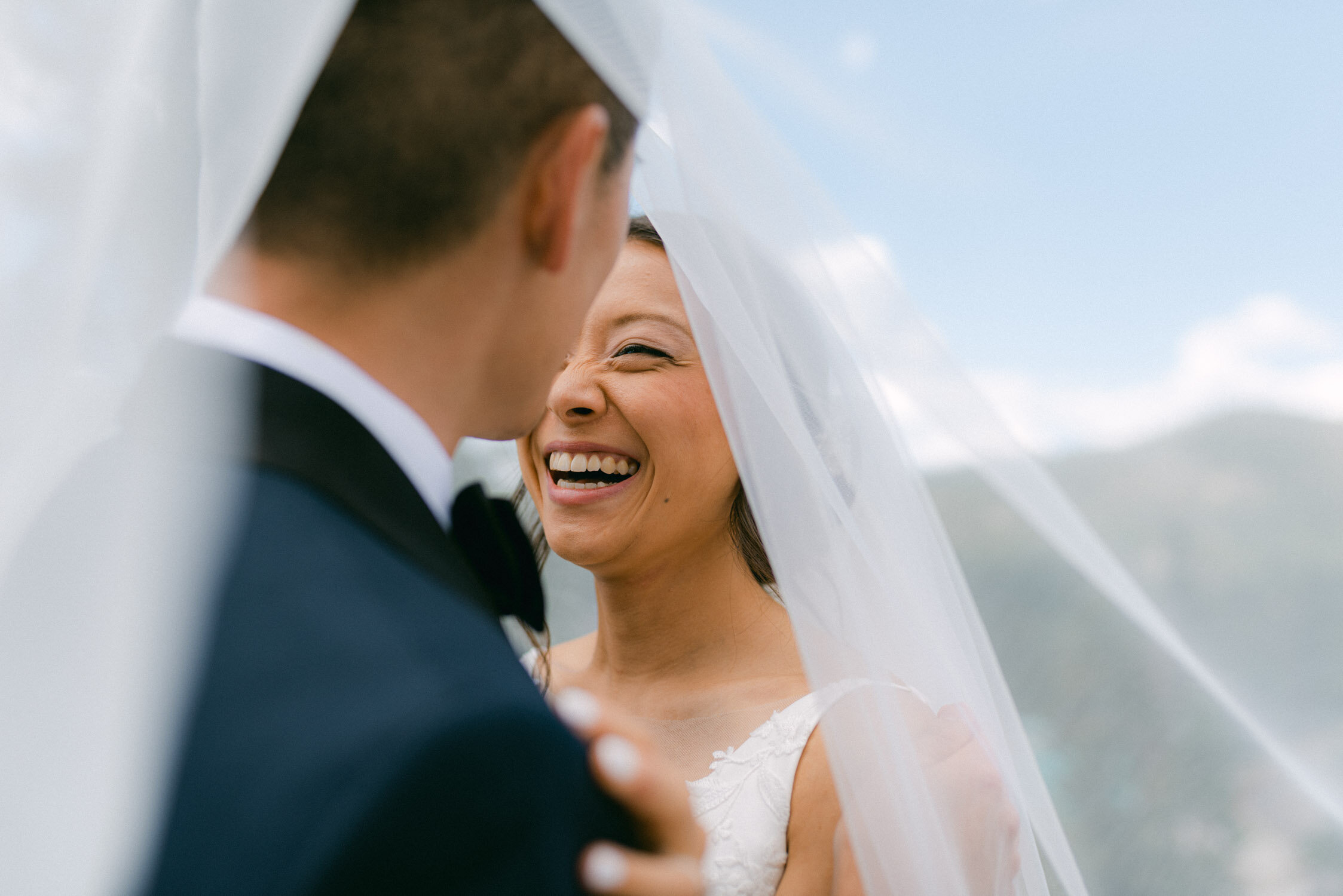 Tahoe Blue Estate Wedding photo of bride smiling with the veil over the couple