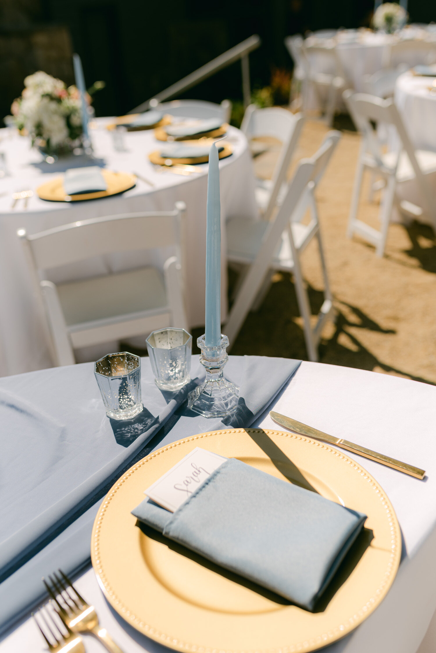 Tahoe Blue Estate Wedding, photo of the reception decor. A gold plate with soft blue napkins