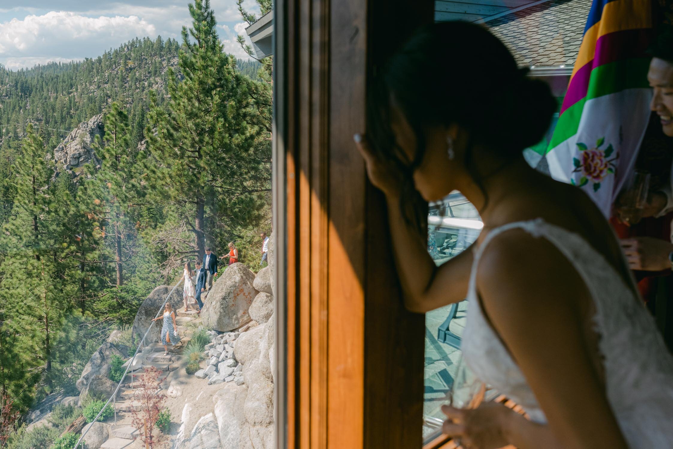 Tahoe Blue Estate Wedding, photo of couple peaking at their wedding guests from the master suite. 
