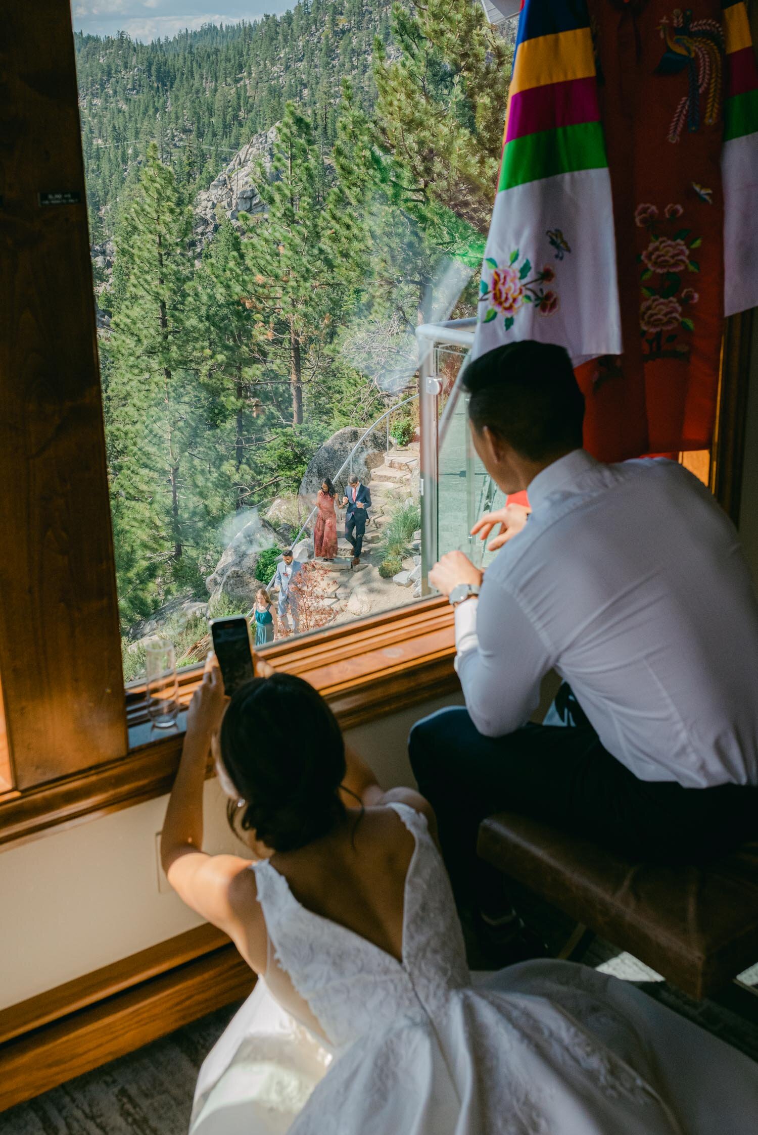 Tahoe Blue Estate Wedding, photo of couple peaking at their wedding guests from the master suite. 