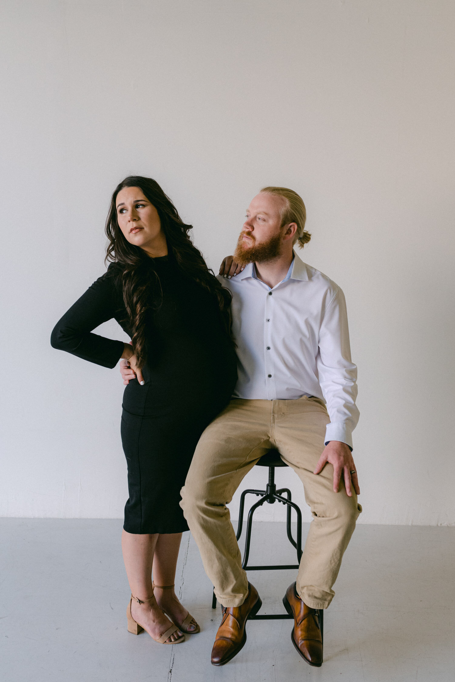 Studio Maternity Session in Reno, with a white background, photo of couple looking away