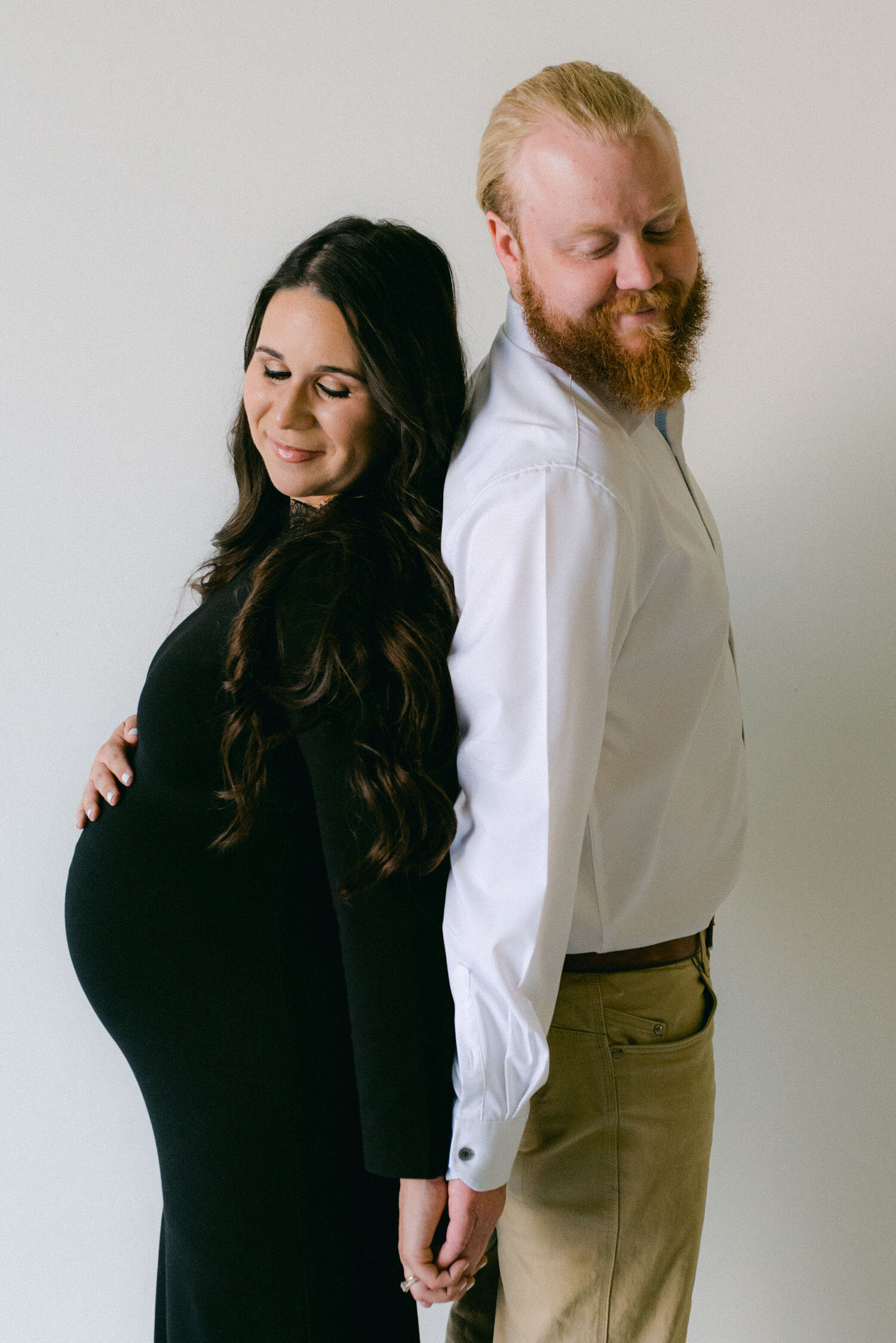 Studio Maternity Session in Reno, with a white background, photo of mom wearing a men's dress shirt for her modern maternity session