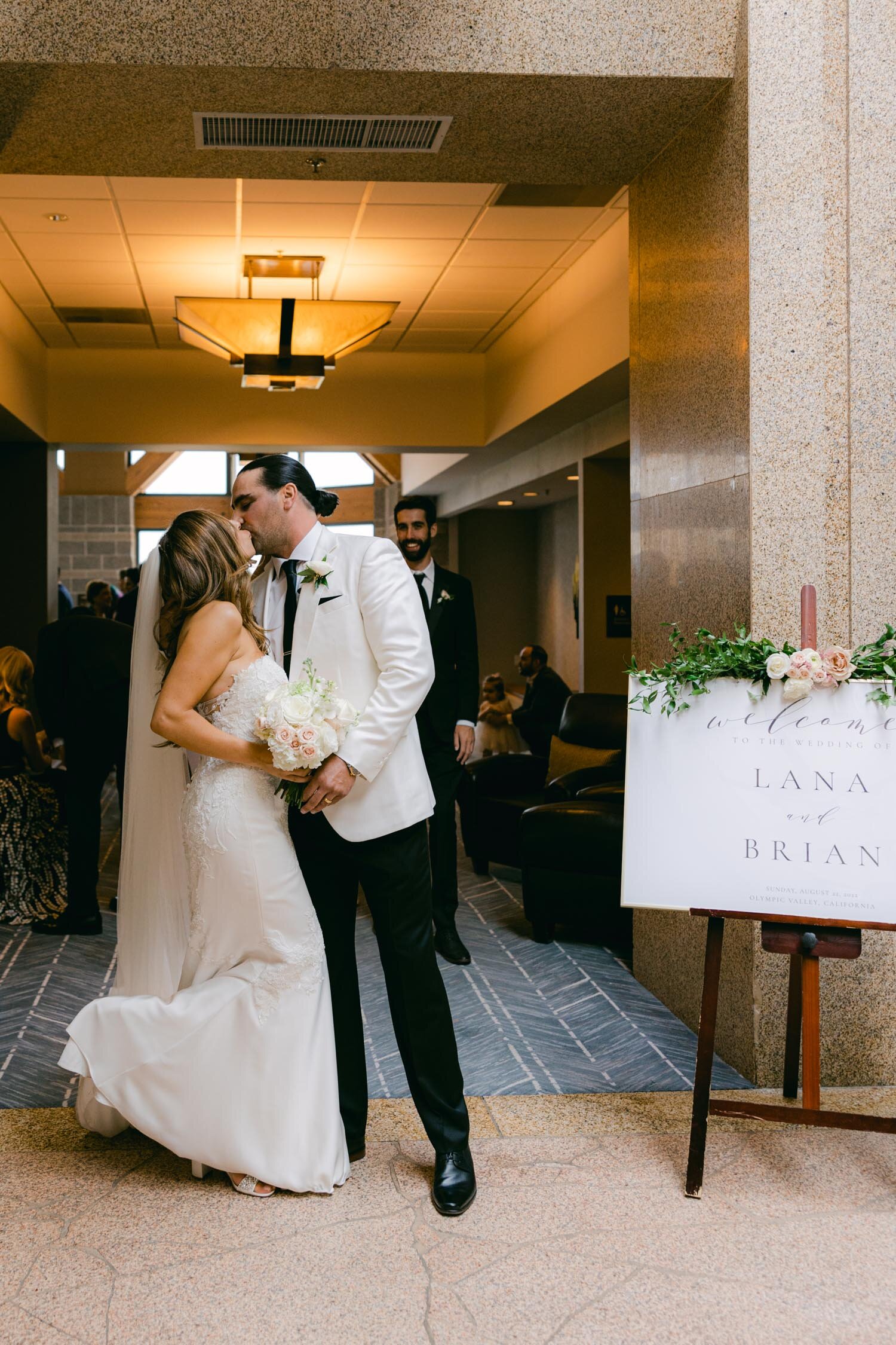 Palisades wedding, photo of couple kissing next to their custom wedding welcome sign