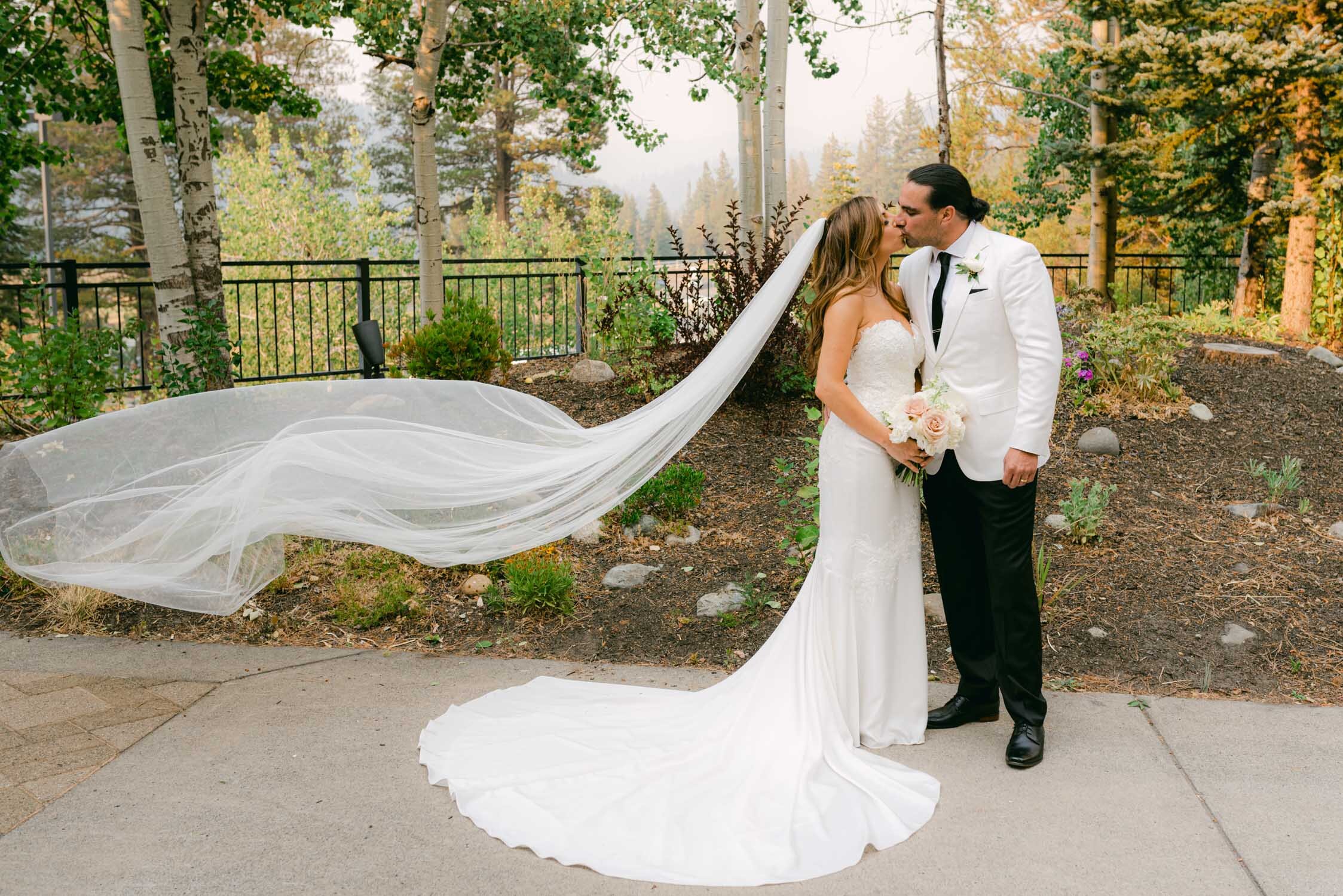 Palisades wedding, photo of couple kissing and bride's veil flying in the air