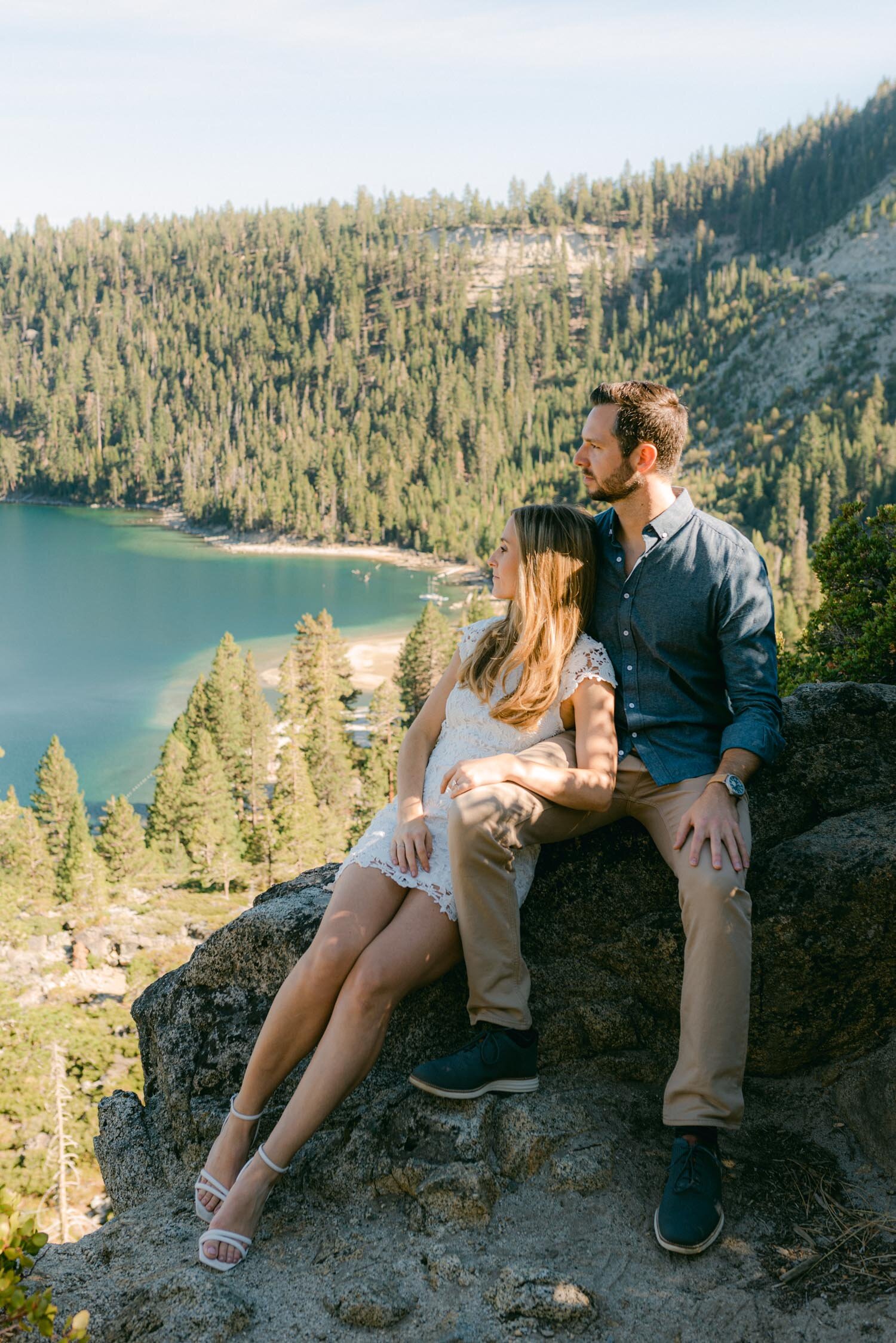 Emerald Bay engagement photoshoot, photo of a couple sitting on a rock overlooking the bay
