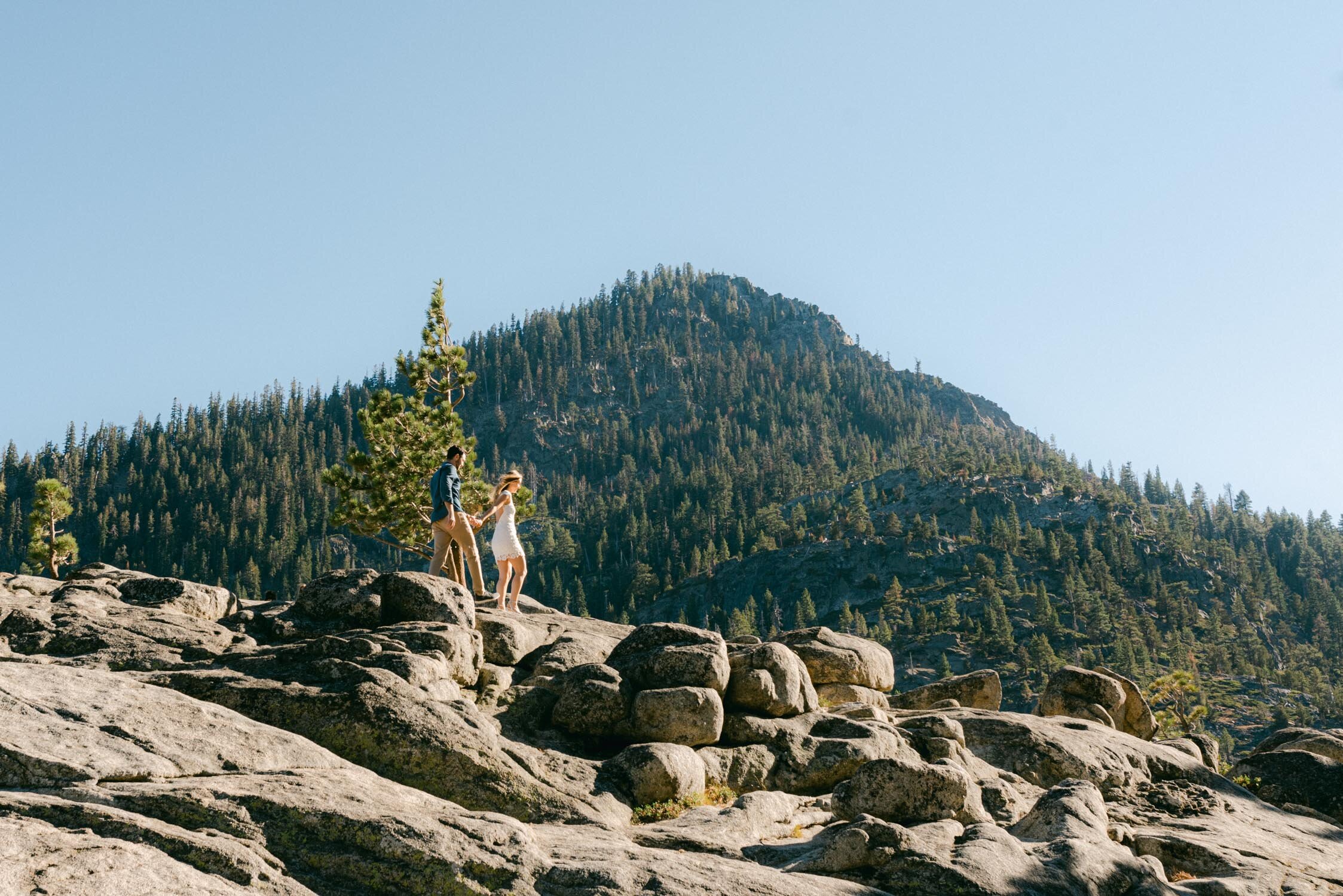Emerald Bay engagement photoshoot, photo of a couple walking on a granite ridge