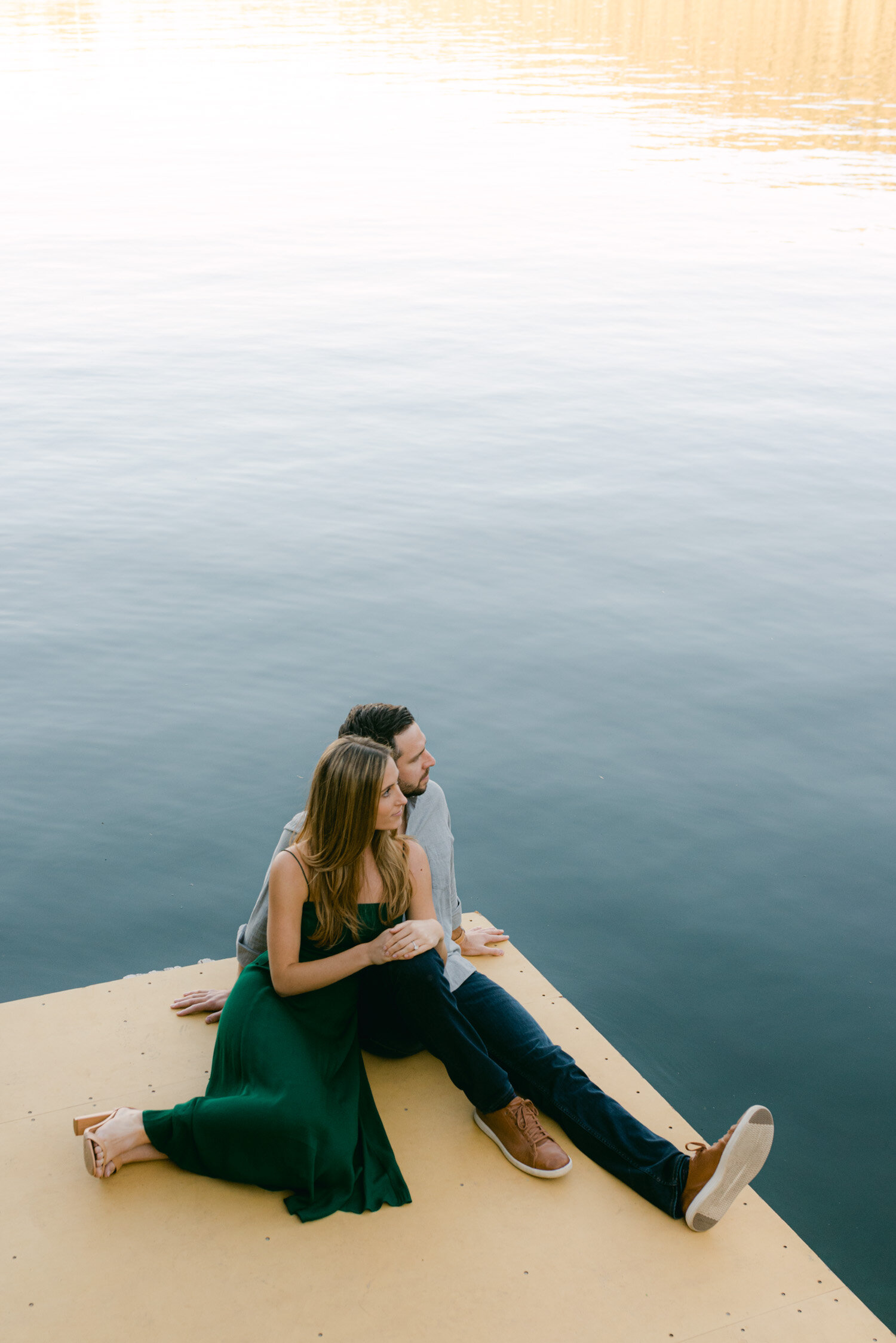 Emerald Bay engagement photoshoot, photo of a couple sitting on a dock
