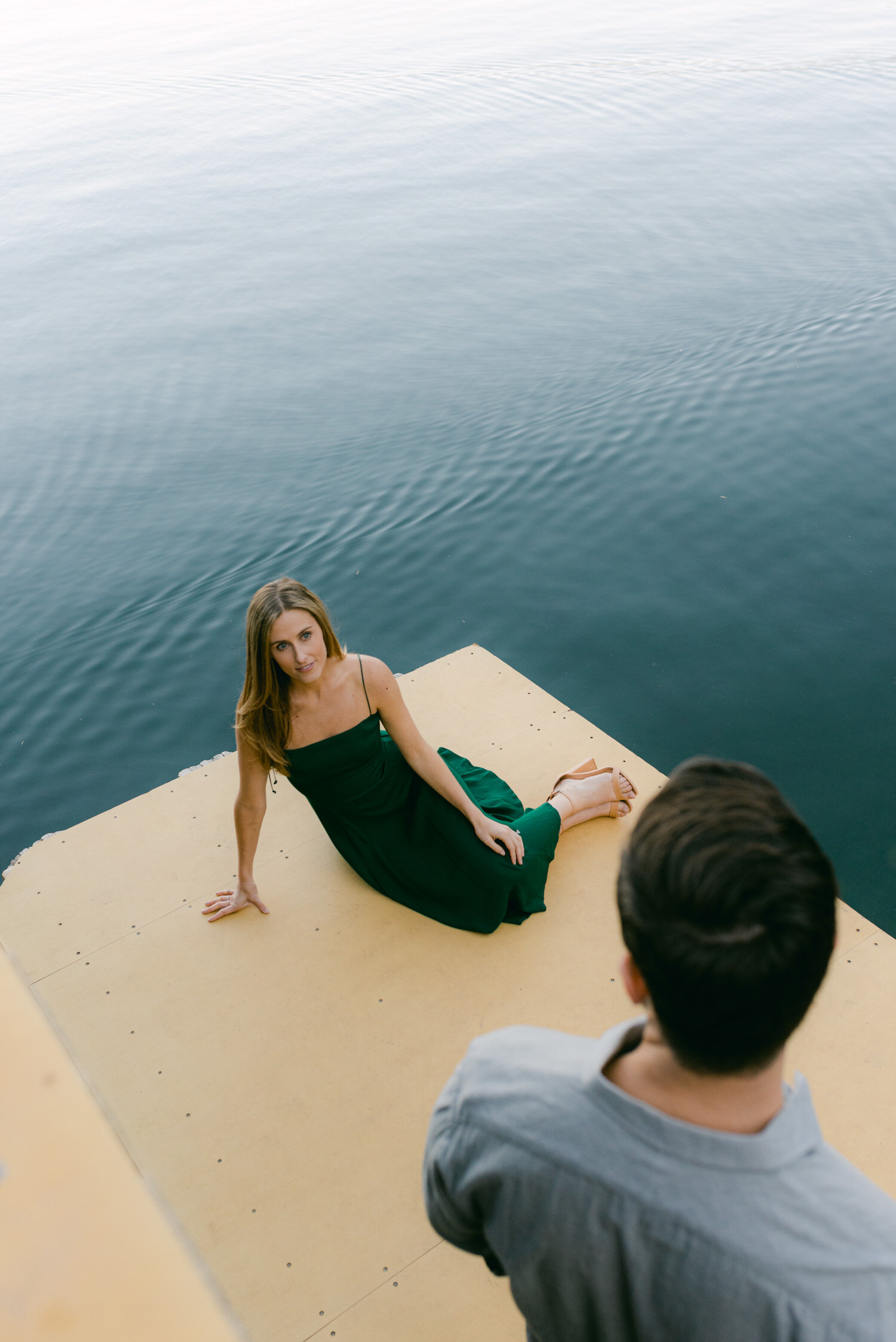 Emerald Bay engagement photoshoot, photo of a couple sitting on a dock and embracing