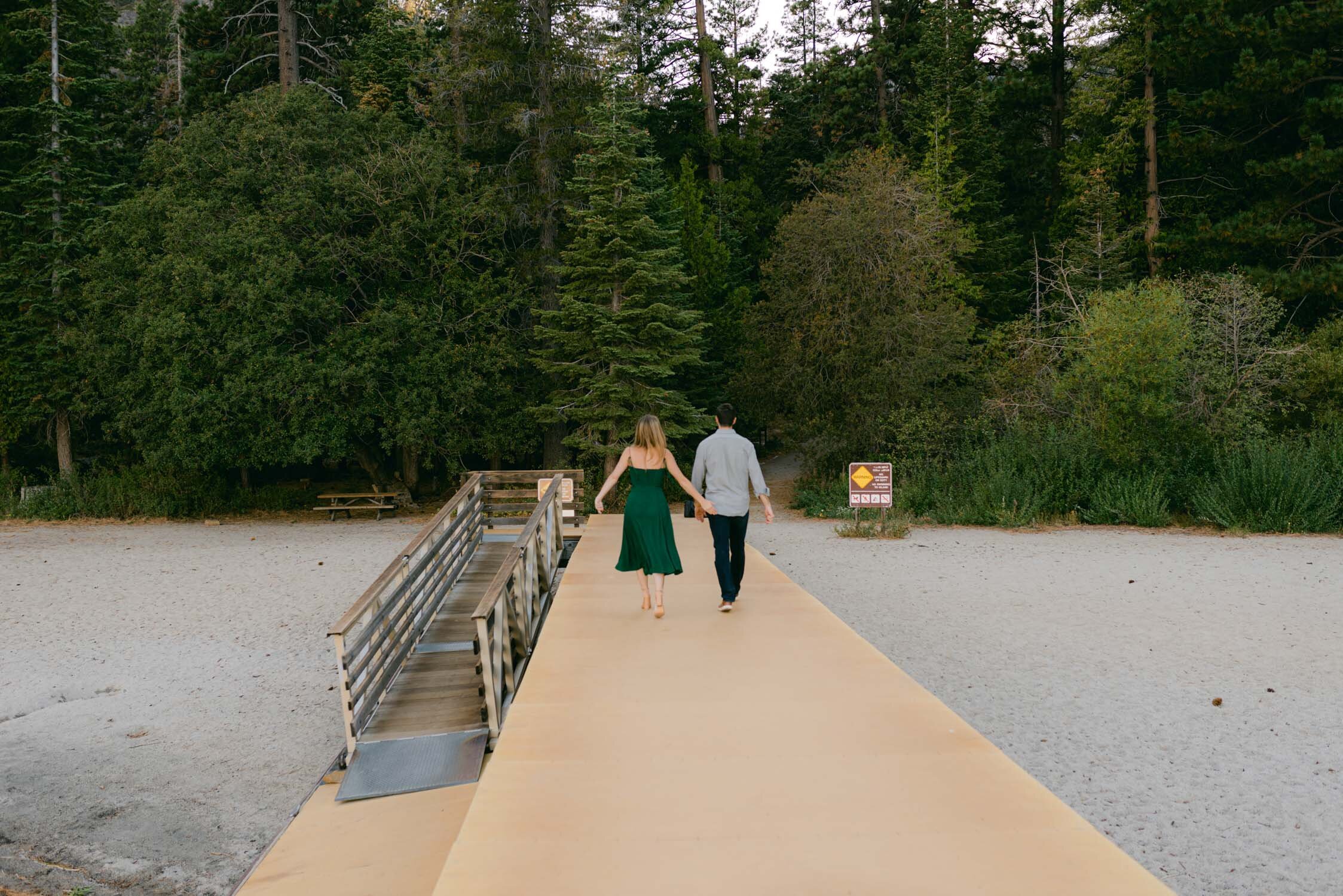 Emerald Bay engagement photoshoot, photo of a couple walking away on a dock