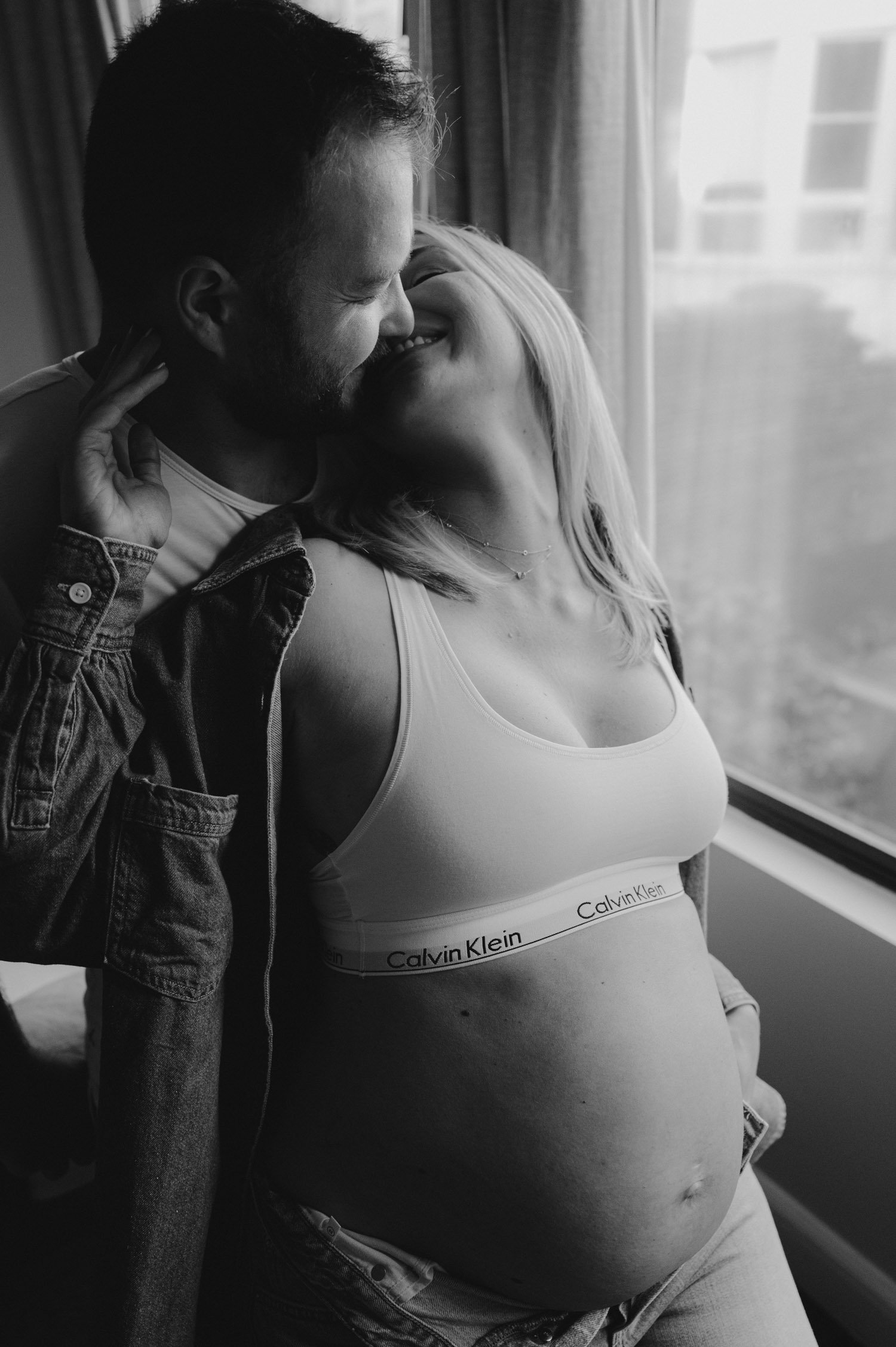 san francisco home maternity session, photo of mom-to-be wearing a calvin klein sports bra and jeans 