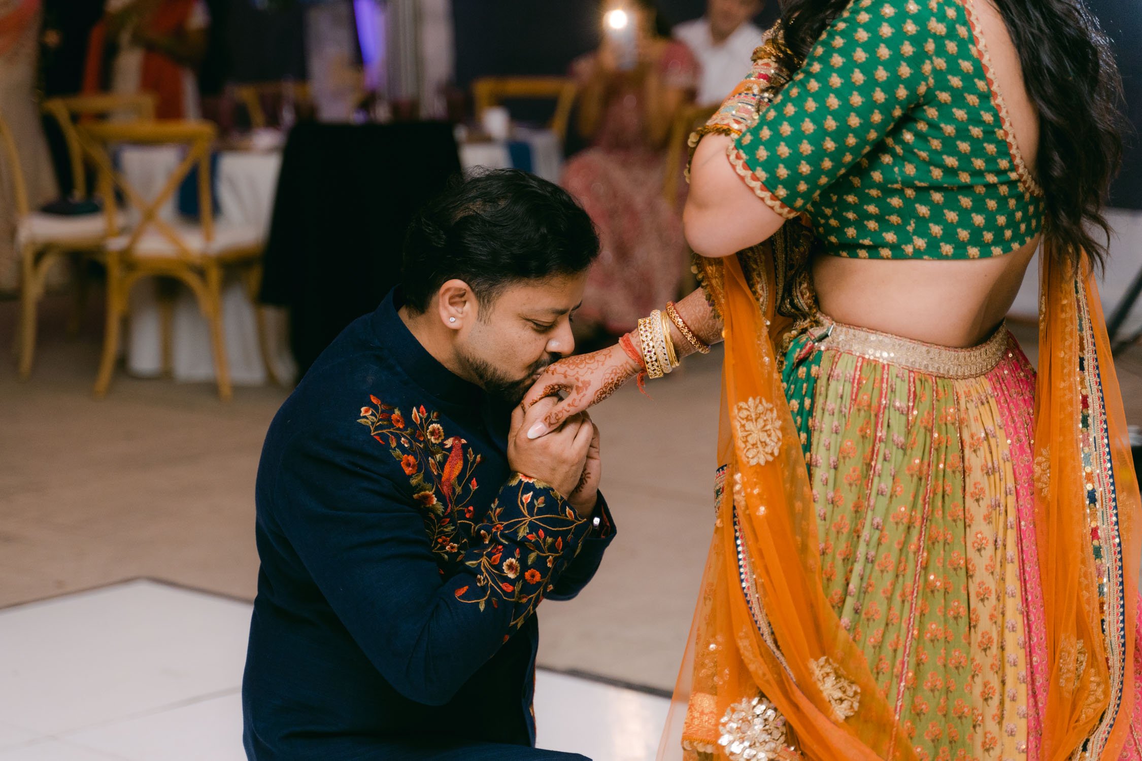 Indian wedding reception, photo of groom kissing his bride's hand
