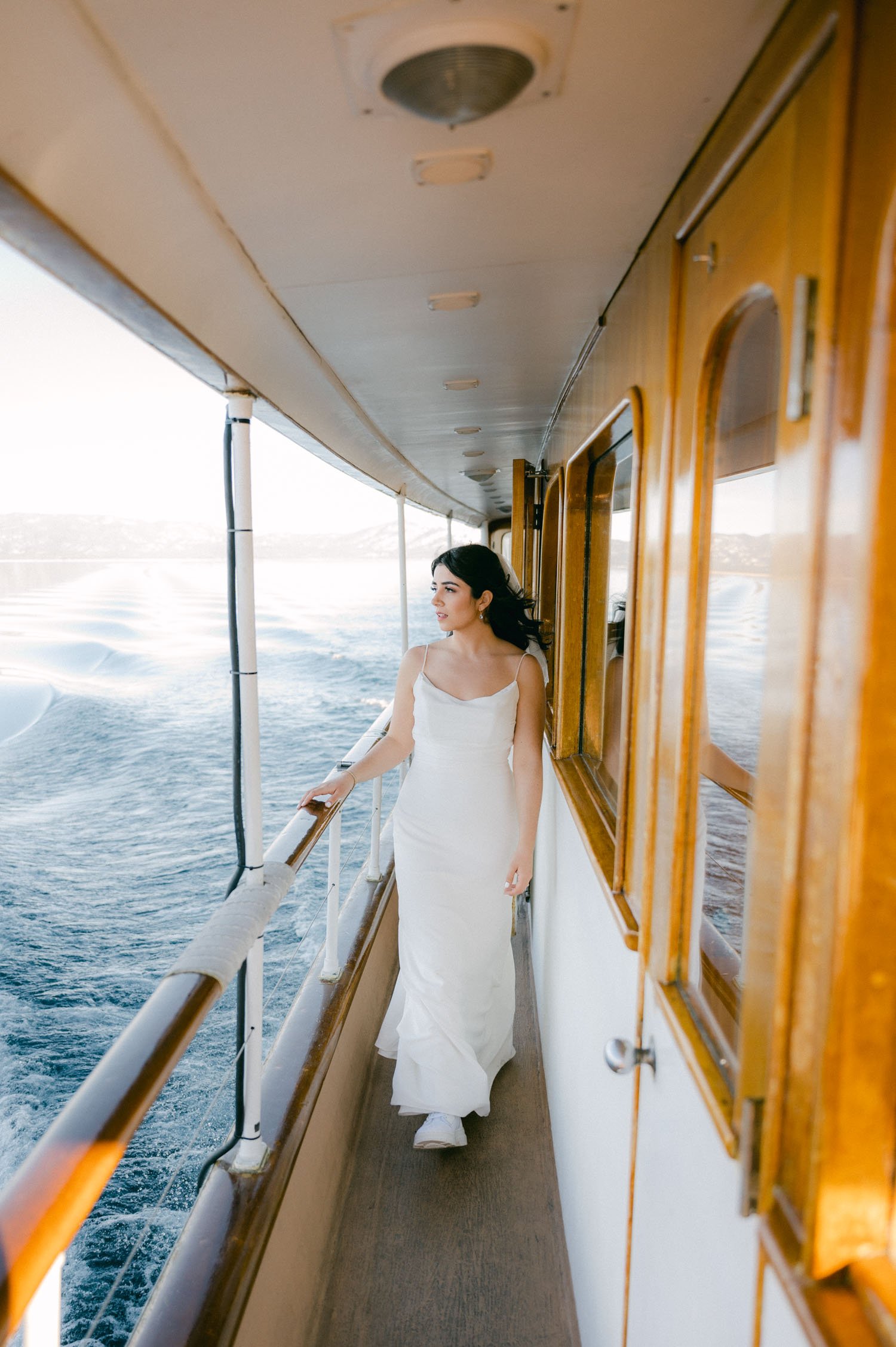 Tahoe Bleu Wave Wedding photo of bride walking on the side of the boat