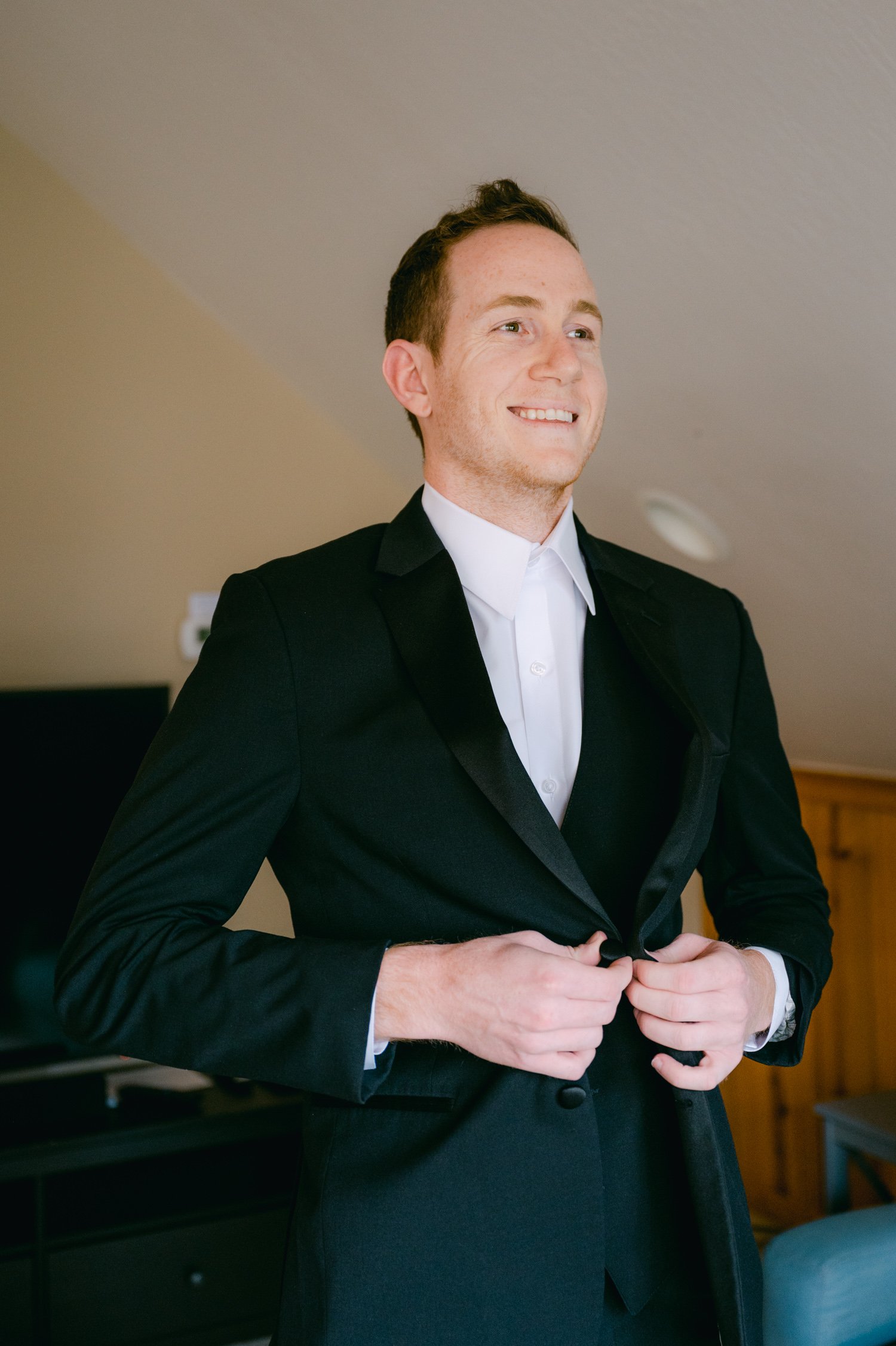 Lake Tahoe elopement, photo of groom putting on his suit