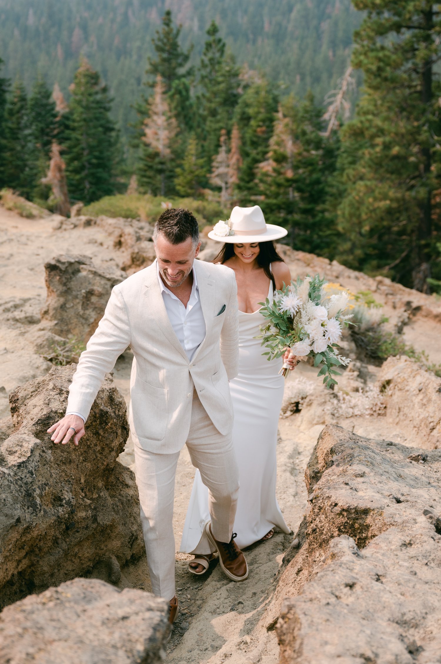 Lake Tahoe Yacht wedding, photo of couple scrambling on a mountain in their wedding attire 