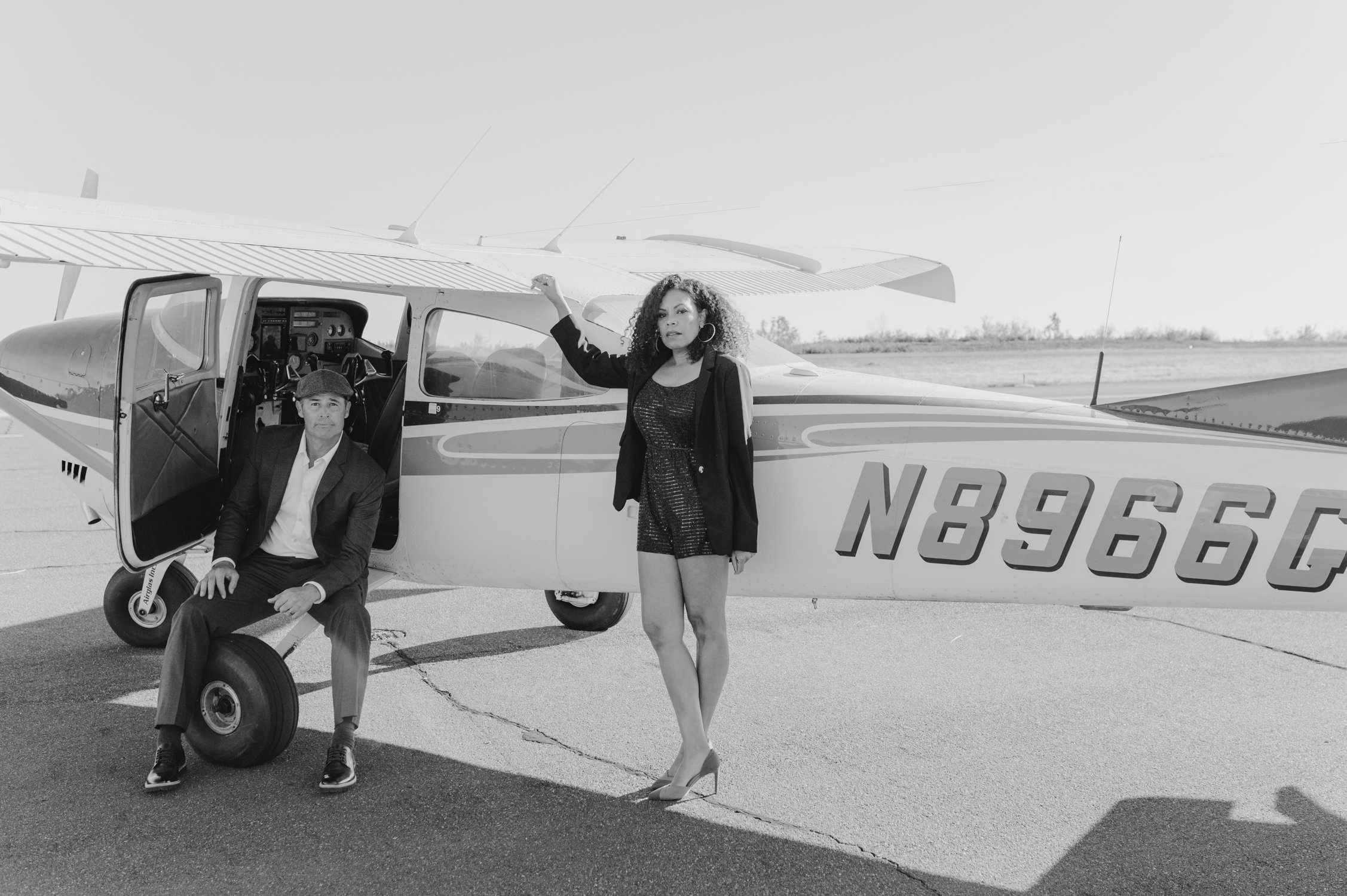 Airport photoshoot, photo of couple standing by the plane. 