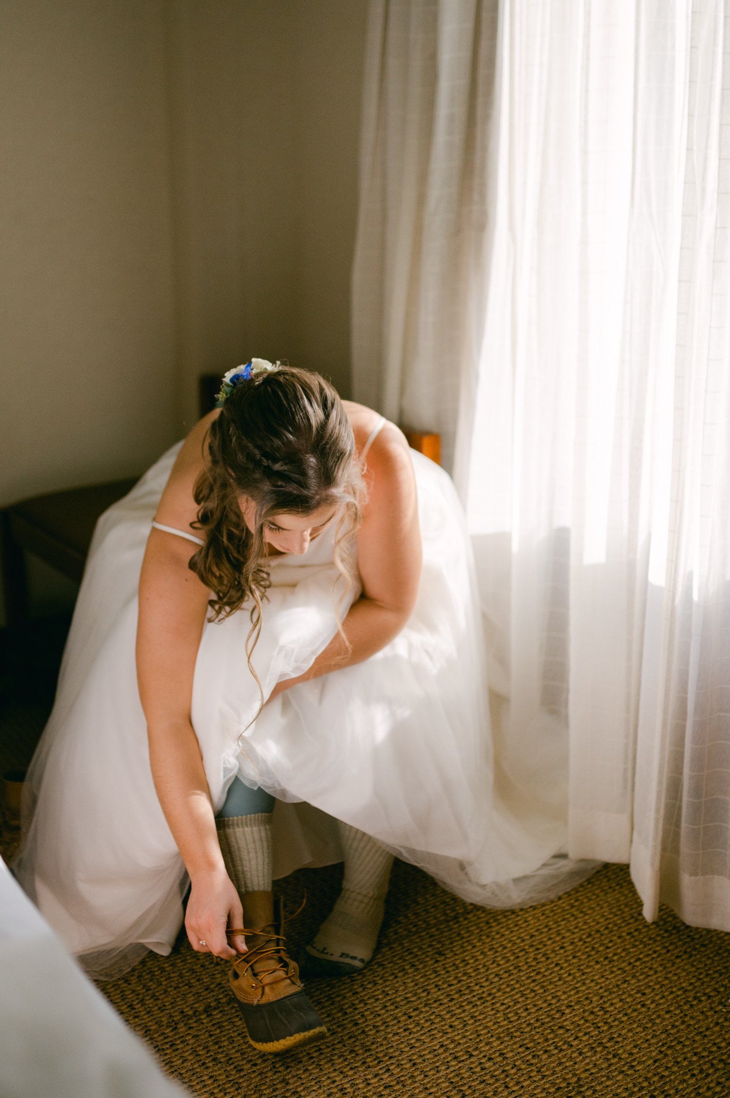 Girdwood Alaska helicopter elopement, photo of bride putting on her wedding boots