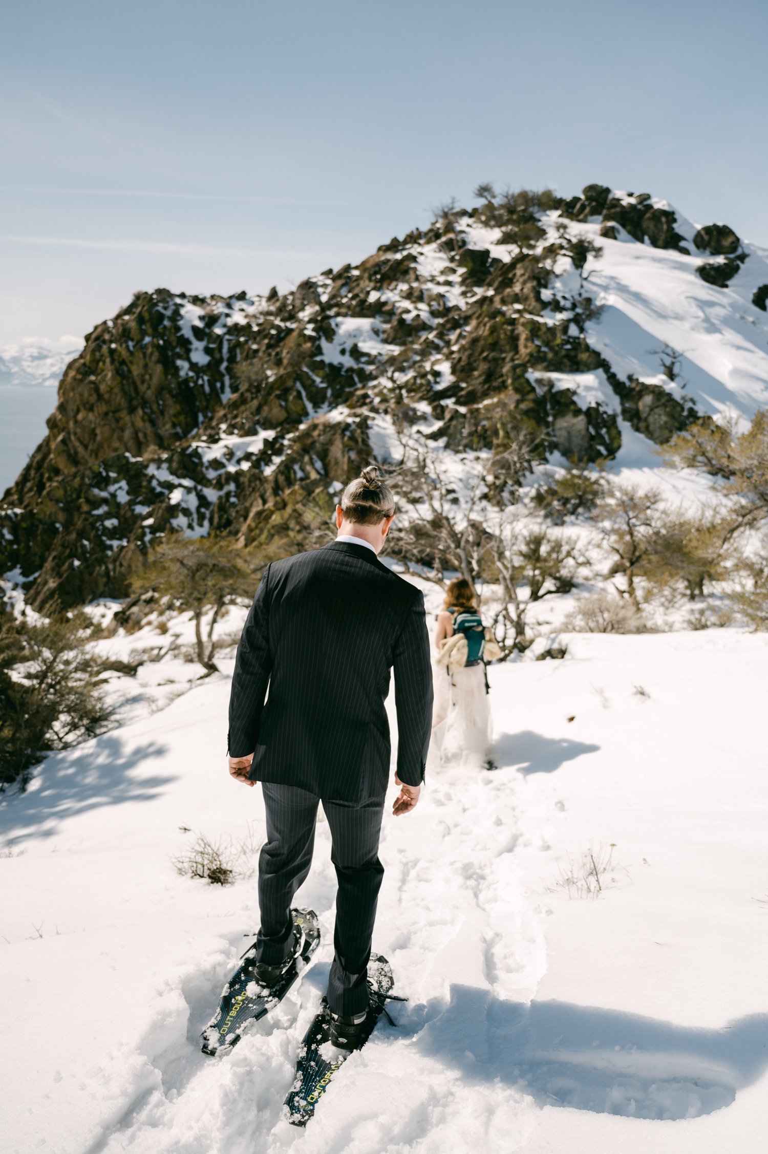 An elopement during a historic winter in tahoe, photo of couple snowshoeing on their wedding day